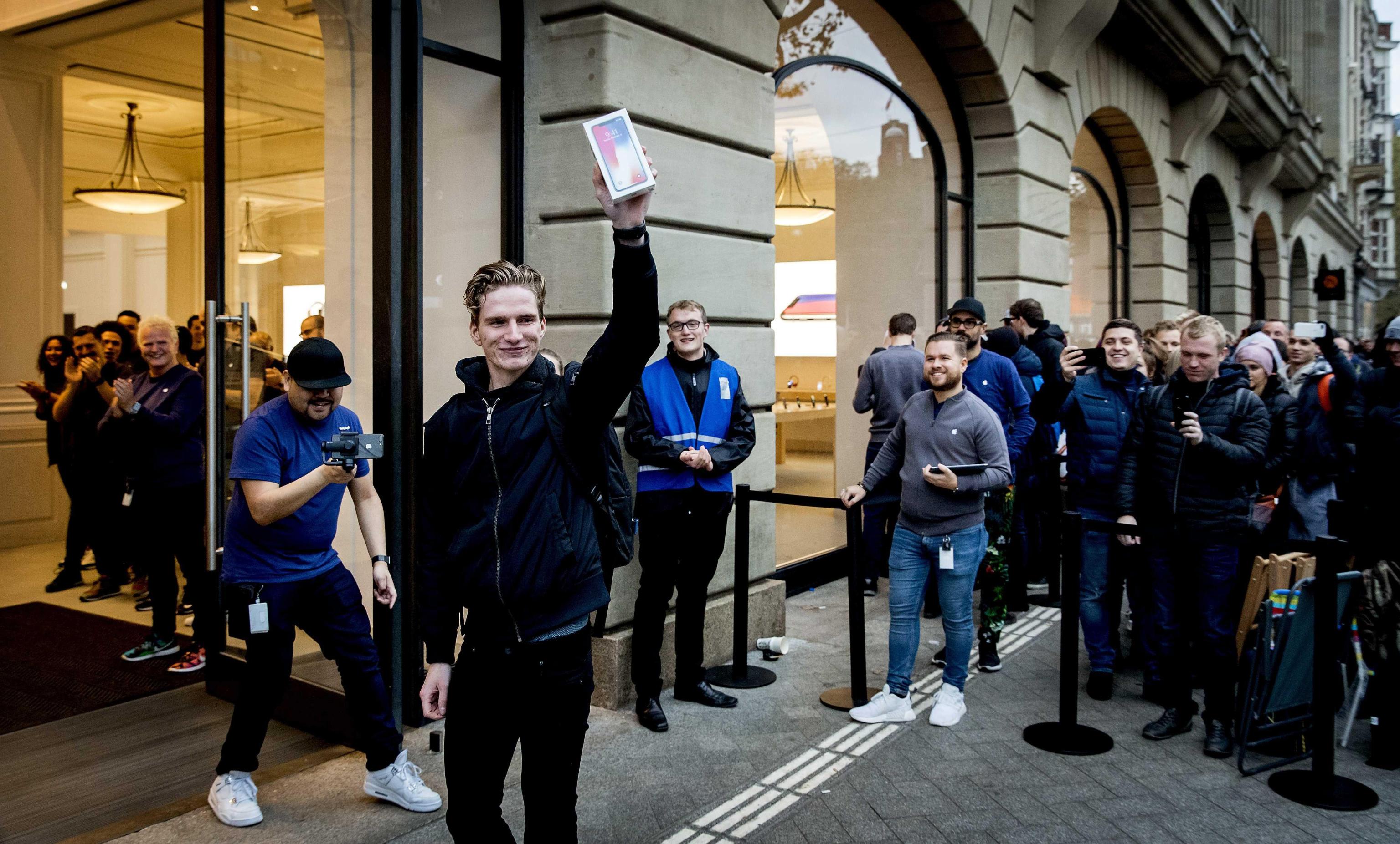 epa06305424 A customer with the new iPhone X outside an Apple store during the launch of the new iPhone X in Amsterdam, The Netherlands, 03 November 2017. Apple's new iPhone X goes  on sale in more than 55 countries and territories on 03 November.  EPA/KOEN VAN WEEL