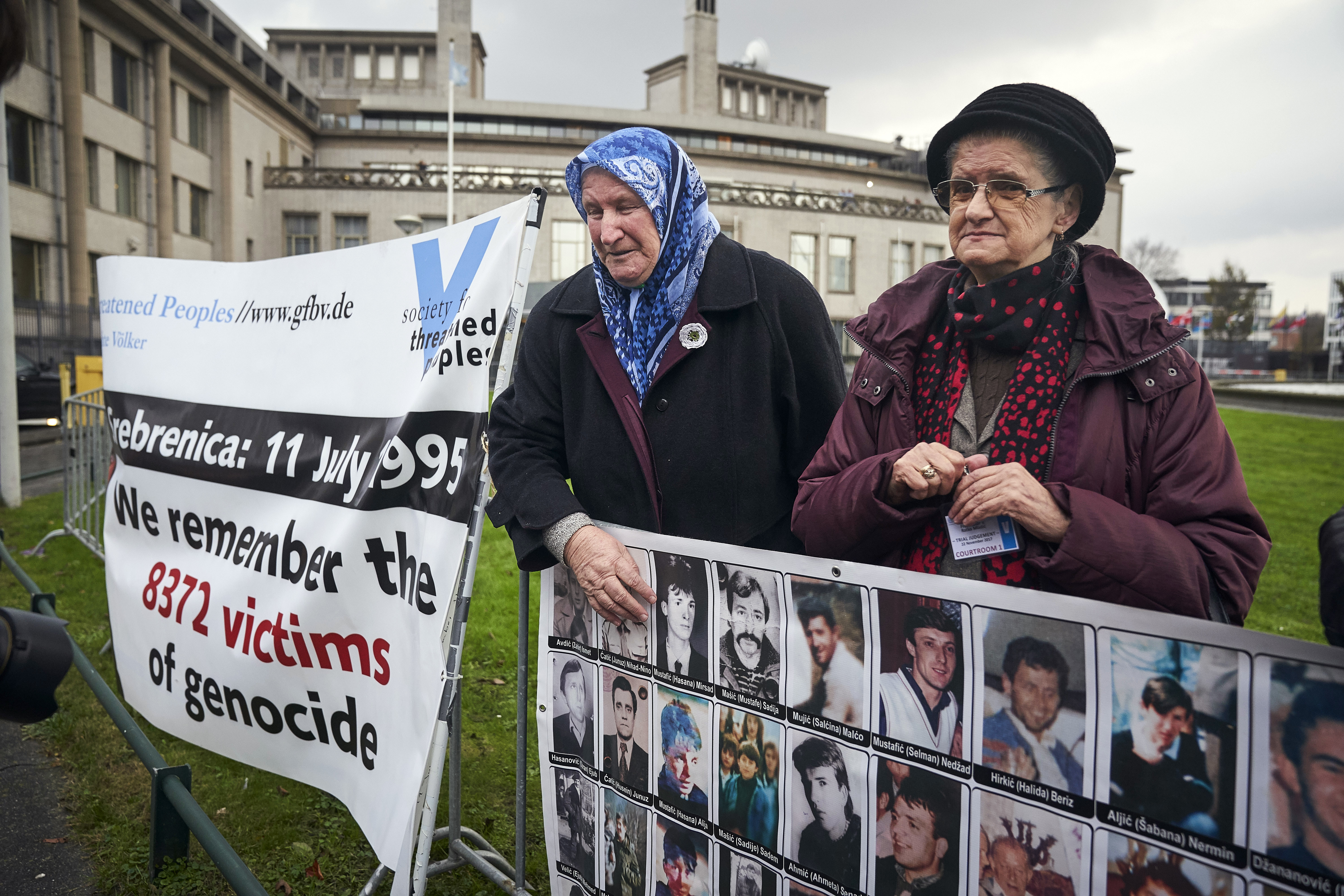 Demonstrators hold banners outside the Yugoslav War Crimes Tribunal, ICTY, where they wait for the verdict to be handed down in the genocide trial against former Bosnian Serb military chief Ratko Mladic, in The Hague, Netherlands, Wednesday Nov. 22, 2017. (AP Photo/Phil Nijhuis)