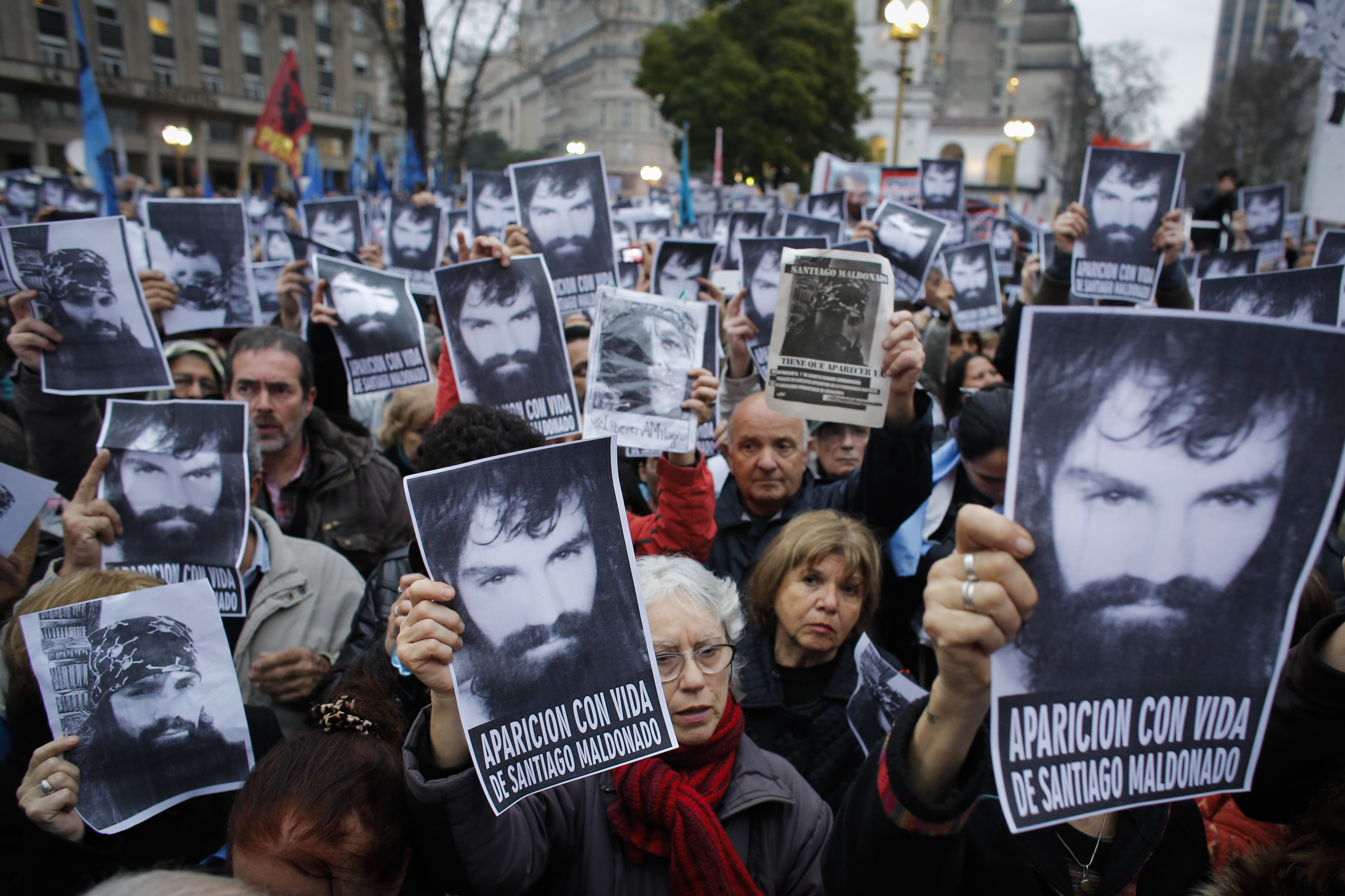 FILE - In this Aug. 11, 2017 file photo, people hold up posters with an image of missing activist Santiago Maldonado, 28, during a demonstration at Plaza de Mayo, in Buenos Aires, Argentina. The Inter-American Commission on Human Rights is urging Argentina to find the missing activist last seen when police evicted a group of Mapuche Indians from lands owned by Italian clothing company Benetton. The commission's president said Thursday, Aug. 24, that Argentina should investigate the Aug. 1 disappearance of Maldonado and make its findings public. (AP Photo/Victor R. Caivano, File)