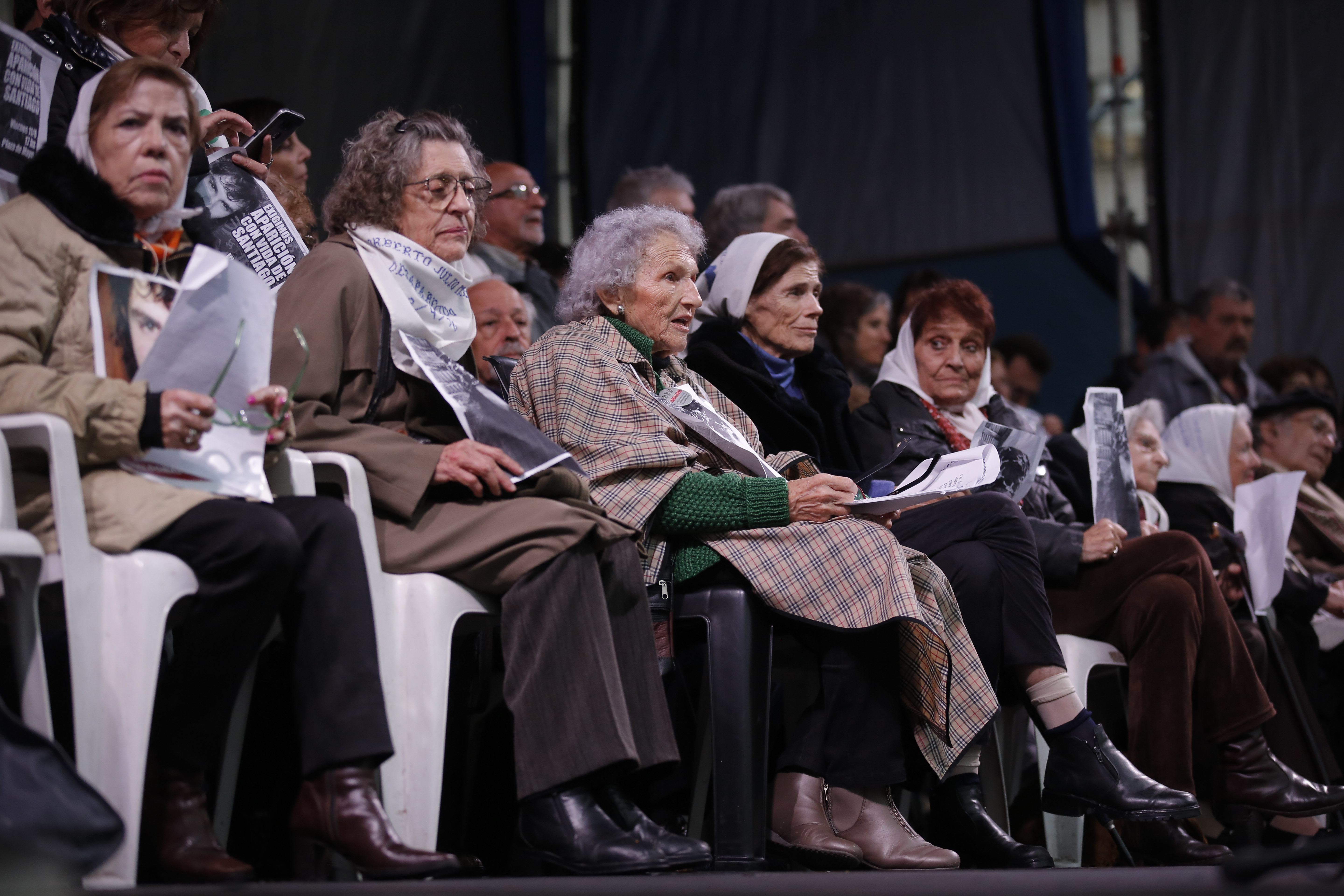 Members of Grandmothers and Mothers of Plaza de Mayo human rights groups sit on stage, some holding a photo of Santiago Maldonado, who's missing, during a demonstration at Plaza de Mayo in Buenos Aires, Argentina, Friday, Aug. 11, 2017. Human rights groups say Maldonado went missing after Argentine border police captured him on Aug. 1 during an operative against Mapuche indigenous who were blocking a highway in Argentina's Patagonia. (AP Photo/Victor R. Caivano)