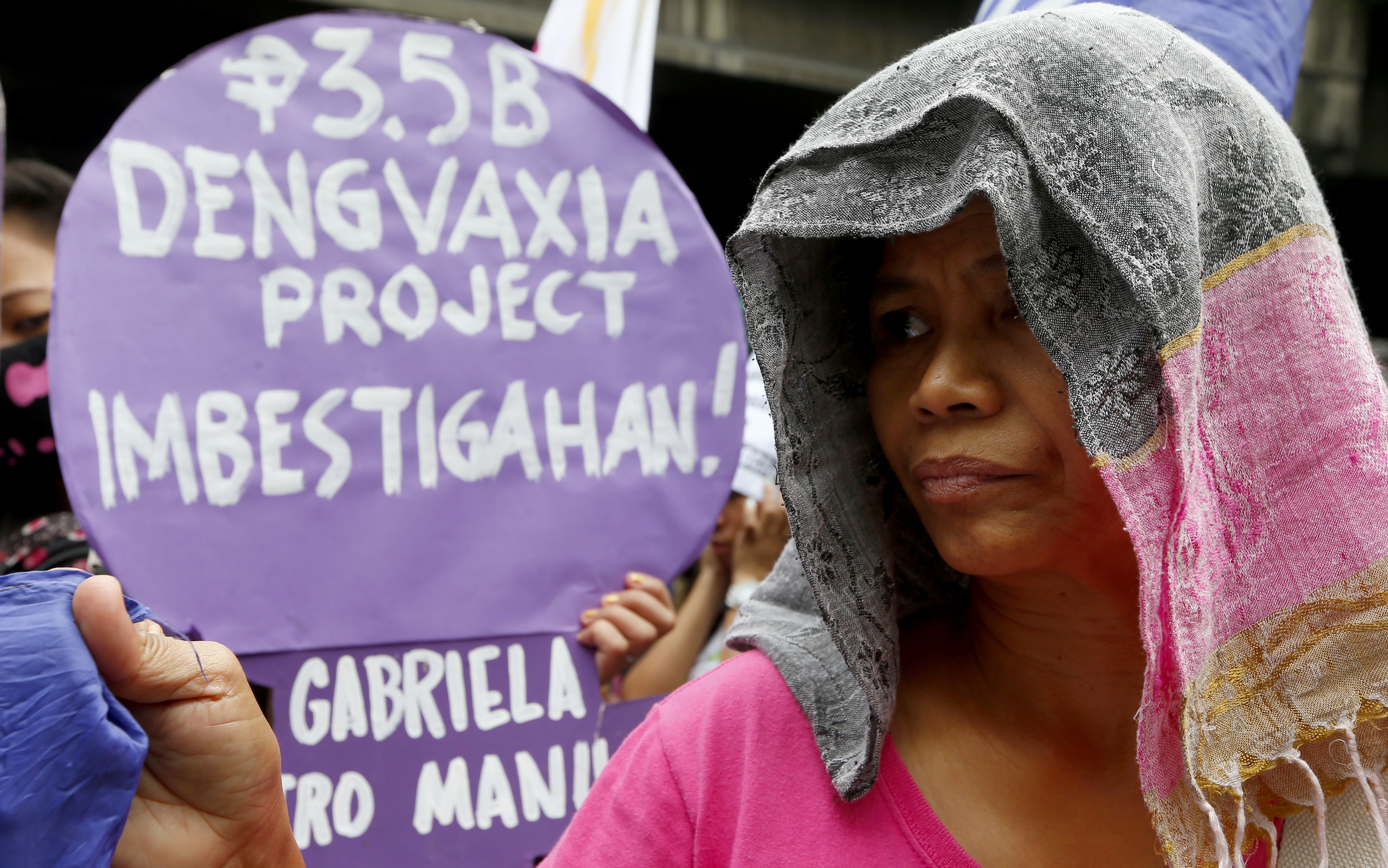 Protesters display placards during a rally outside the Department of Health to demand accountability to Government officials involved in the controversial immunization of  the anti-dengue vaccine Dengvaxia to more than 700,000 Filipino children Tuesday, Dec. 5, 2017 in Manila, Philippines. The controversial vaccine, manufactured by Sanofi Pasteur was put on hold by the Philippines last week after new study findings showed it posed risks of severe cases in people without previous infection. The drug was recalled Tuesday from local health centers. The sign reads: Investigate The 3.5 Billion-Peso Dengvaxia Project.! (AP Photo/Bullit Marquez)