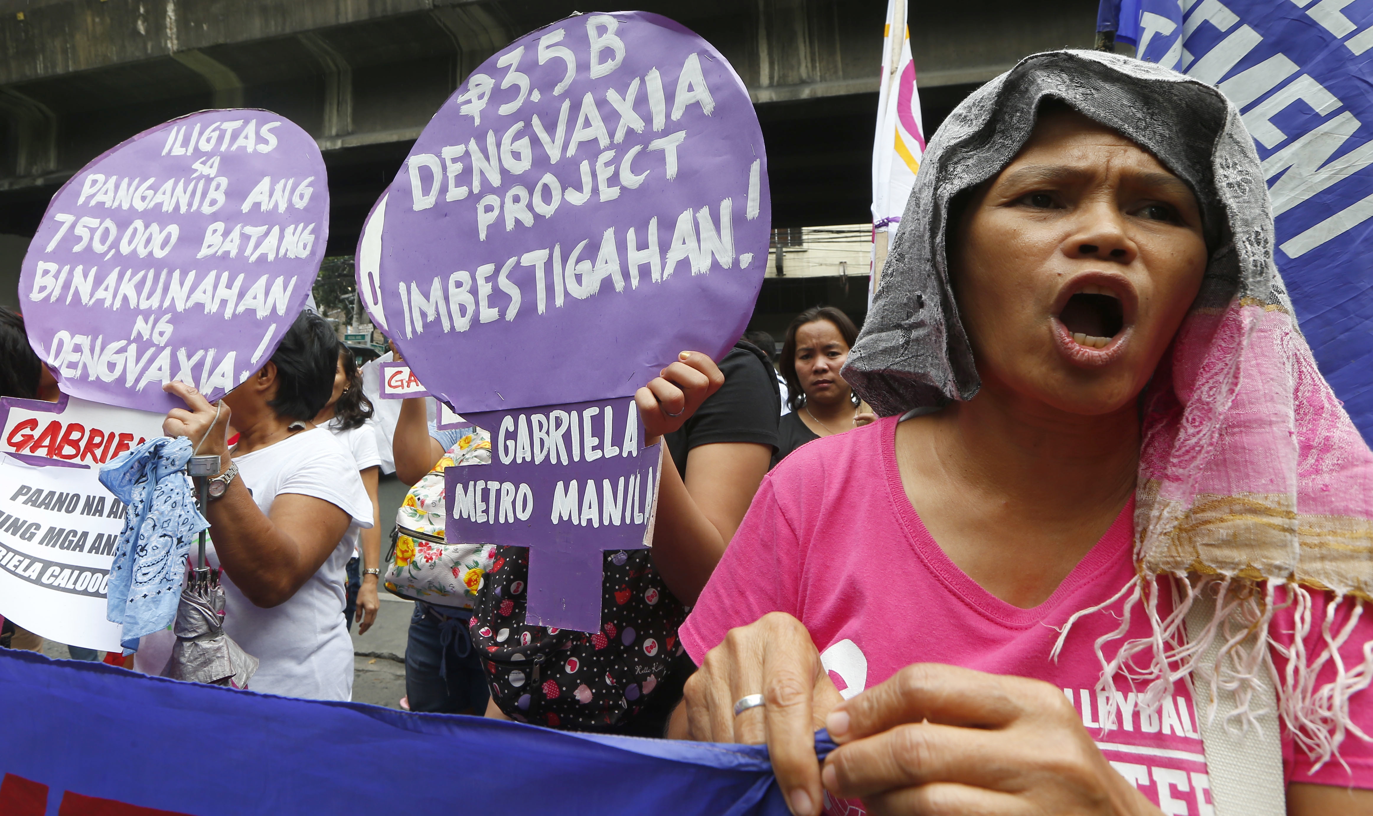 Protesters shout slogans during a rally outside the Department of Health to demand accountability to Government officials involved in the controversial immunization of  the anti-dengue vaccine Dengvaxia to more than 700,000 Filipino children Tuesday, Dec. 5, 2017 in Manila, Philippines. The controversial vaccine, manufactured by Sanofi Pasteur was put on hold by the Philippines last week after new study findings showed it posed risks of severe cases in people without previous infection. The drug was recalled Tuesday from local health centers. The sign in center reads: Investigate The 3.5 Billion-Peso Dengvaxia Project.! (AP Photo/Bullit Marquez)