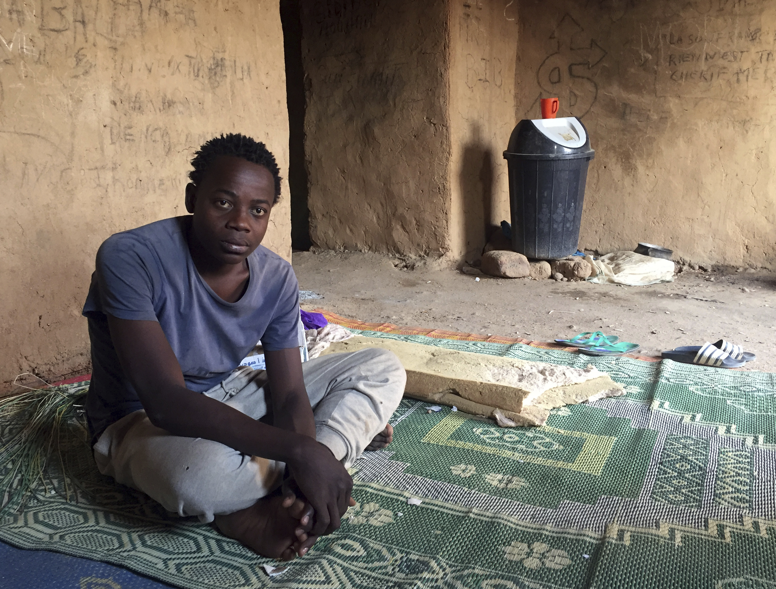 A 17-year-old migrant from the West African Ivory Coast sitting in a ghetto of the Niger city Agadez, a transition point for refugees on the edge of the Sahara, in Agadez, Niger, 27 October 2017. Photo by: Kristin Palitza/picture-alliance/dpa/AP Images