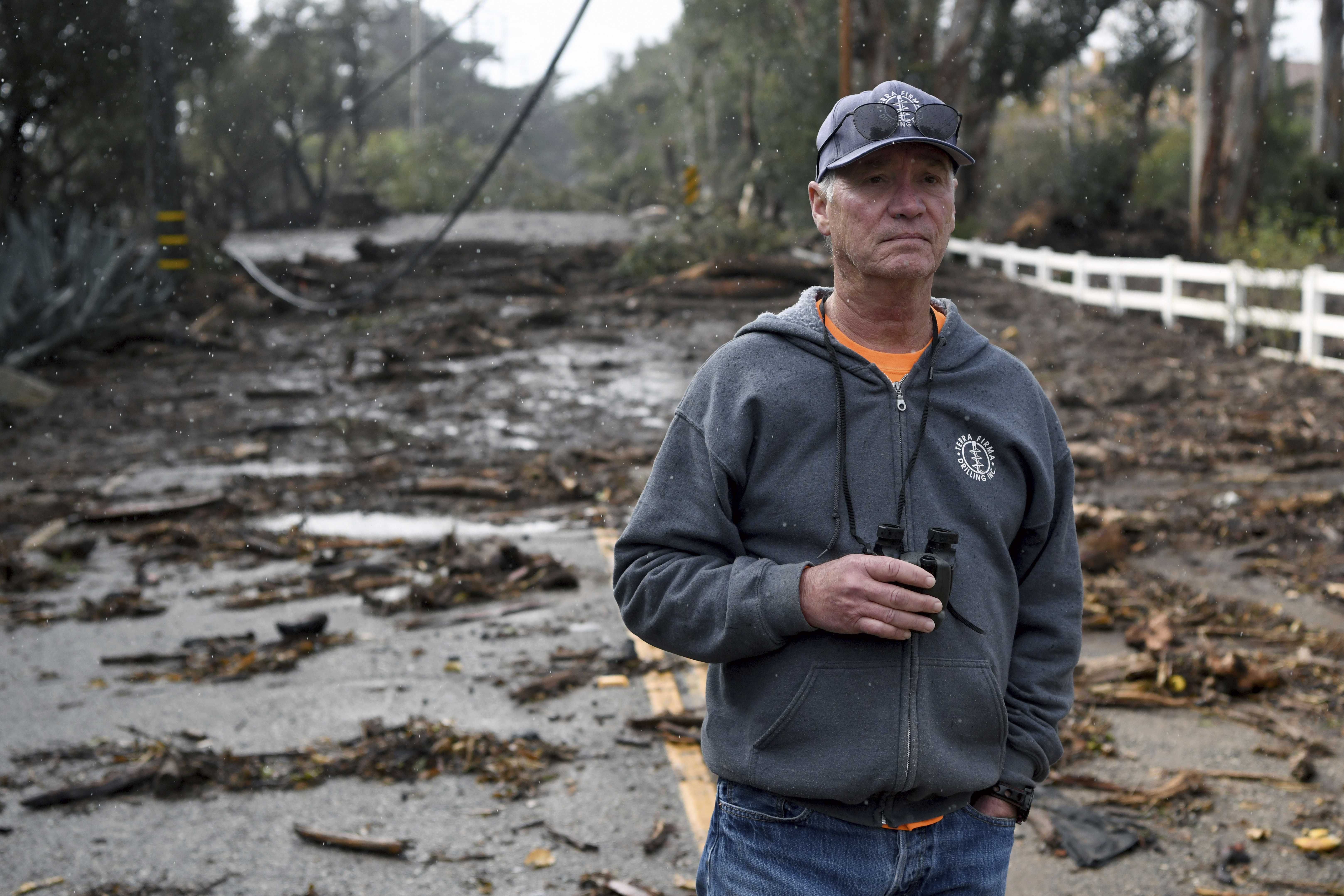 Montecito resident Donald Crouse surveys the damage on East Valley Road in Montecito, Calif., where utility lines fell onto a bridge during the rain storm, Tuesday, Jan. 9, 2018. (AP Photo/Michael Owen Baker)