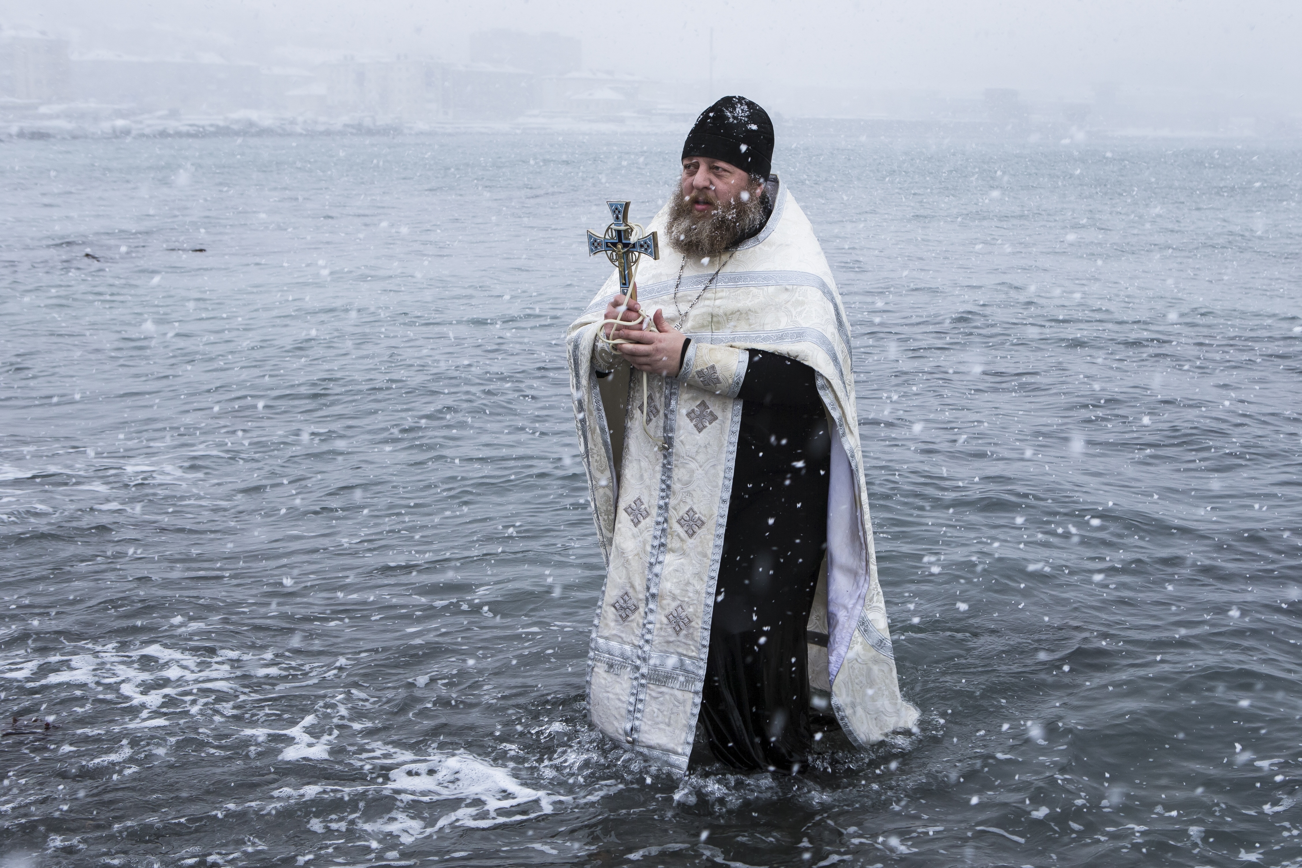 Russian monk Sergius blesses sea water before bathing on Epiphany in Kholmsk, 90 kilometers (56 miles ) west of Yuzhno-Sakhalinsk, Sakhalin Island in Russia's Far East. Water that is blessed by a cleric on Epiphany is considered holy and pure until next year's celebration, and is believed to have special powers of protection and healing. (AP Photo/Sergey Krasnoukhov)