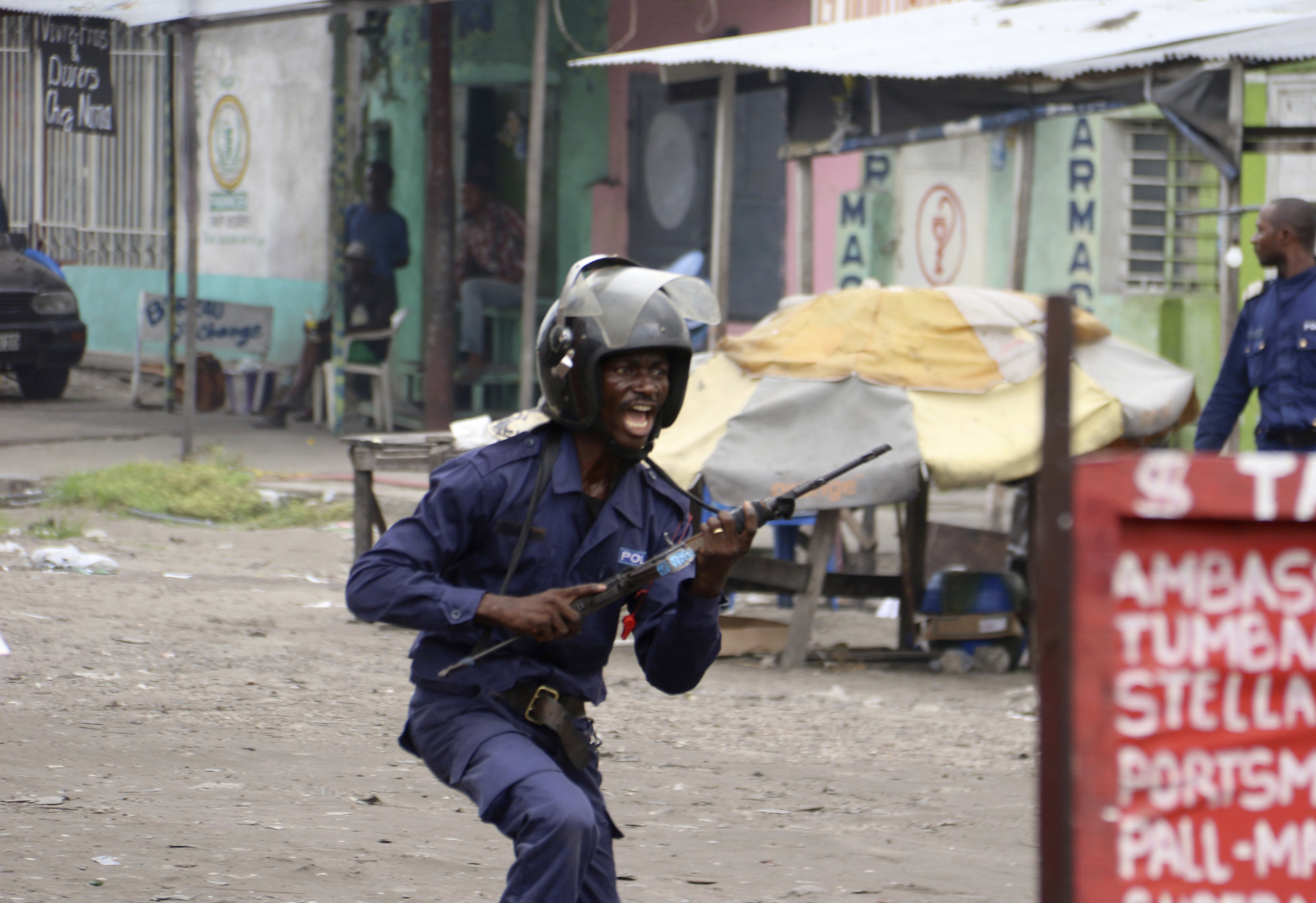 A member of the Congolese security forces chases people during a protest in Kinshasa, Democratic Republic of Congo, Sunday, Dec. 31, 2017. Congolese security forces shot dead two men outside a church on Sunday while dispersing demonstrators protesting in the country's capital against President Joseph Kabila's refusal to step down from power, according to Human Rights Watch. (AP Photo/John Bompengo)