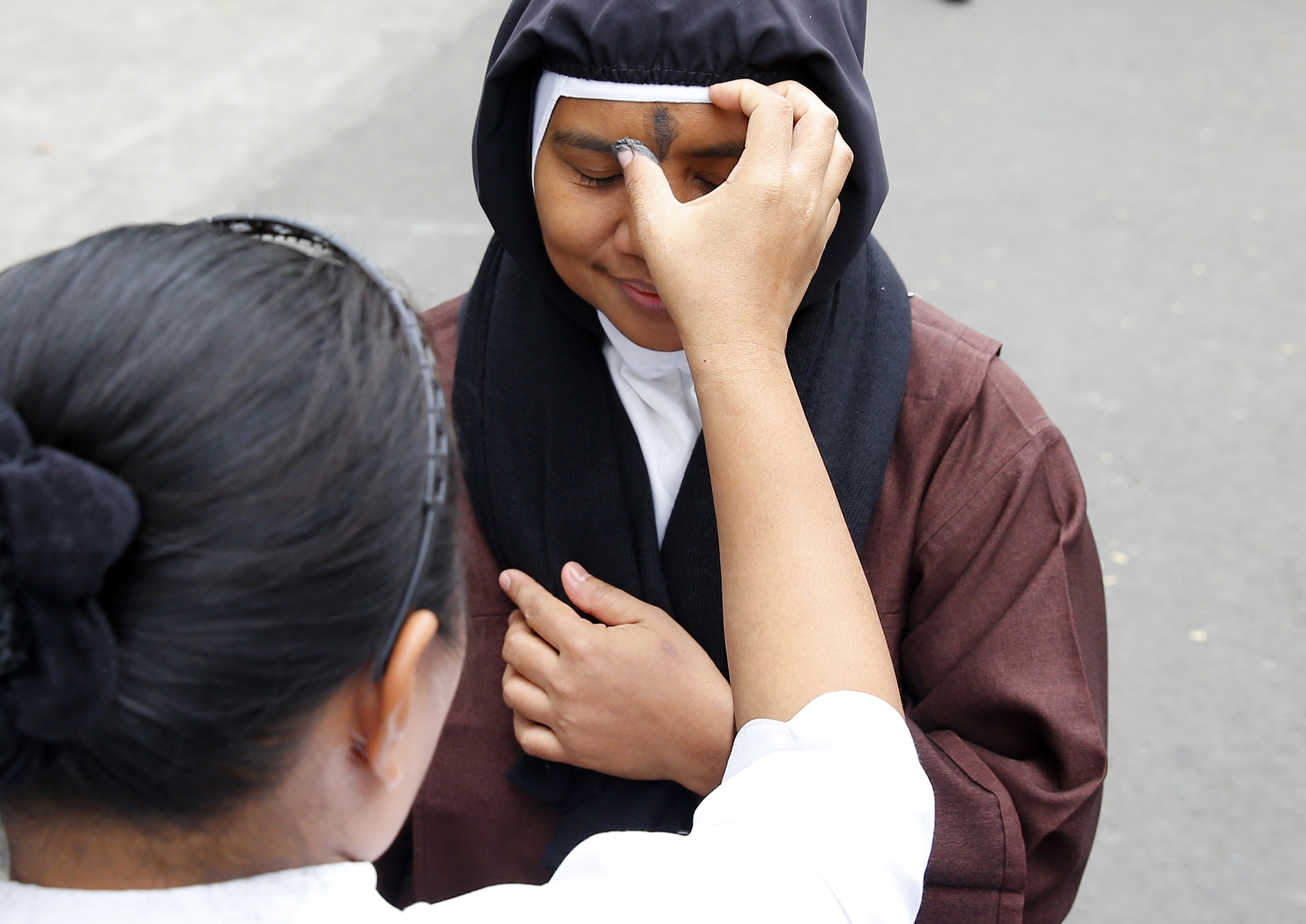 A Roman Catholic nun has her forehead rubbed with ash to usher the season of Lent known as Ash Wednesday and which also coincides with Valentine's Day celebration Wednesday, Feb. 14, 2018, in Paranaque southeast of Manila, Philippines. Ash Wednesday is observed all over the world by Roman Catholics to remind mankind that God created humans from dust. (AP Photo/Bullit Marquez)