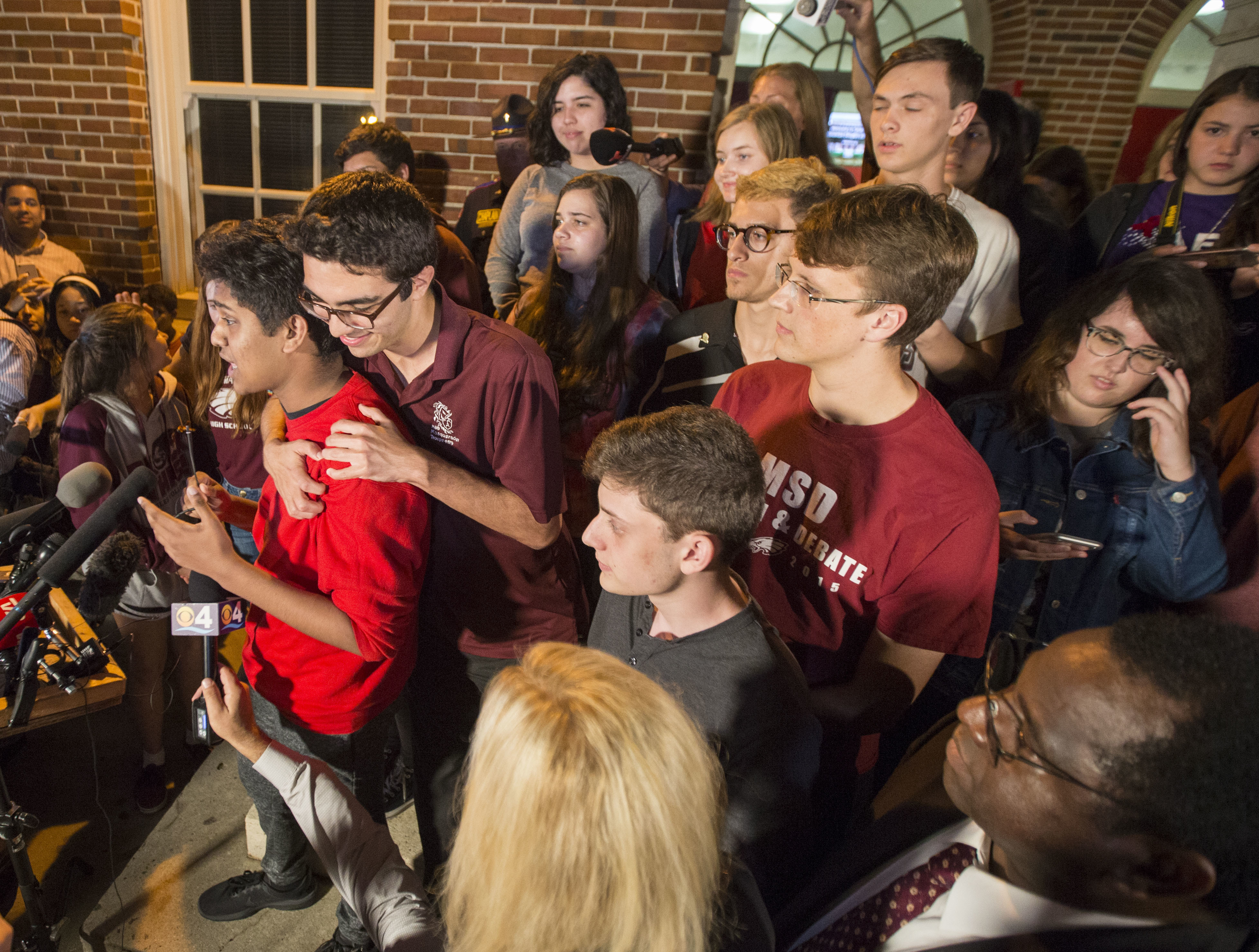 Marjory Stoneman Douglas High School survivors Tanzil Philip, left, is comforted by fellow student Diego Pfeiffer as Philip speaks to Leon High School students after arriving in Tallahassee, Fla., Tuesday, Feb 20, 2018. The students from Douglas High School are in town to lobby the Florida legislature after a shooting at their school by a former student that left more than a dozen students and faculty dead and others injured last week. (AP Photo/Mark Wallheiser)