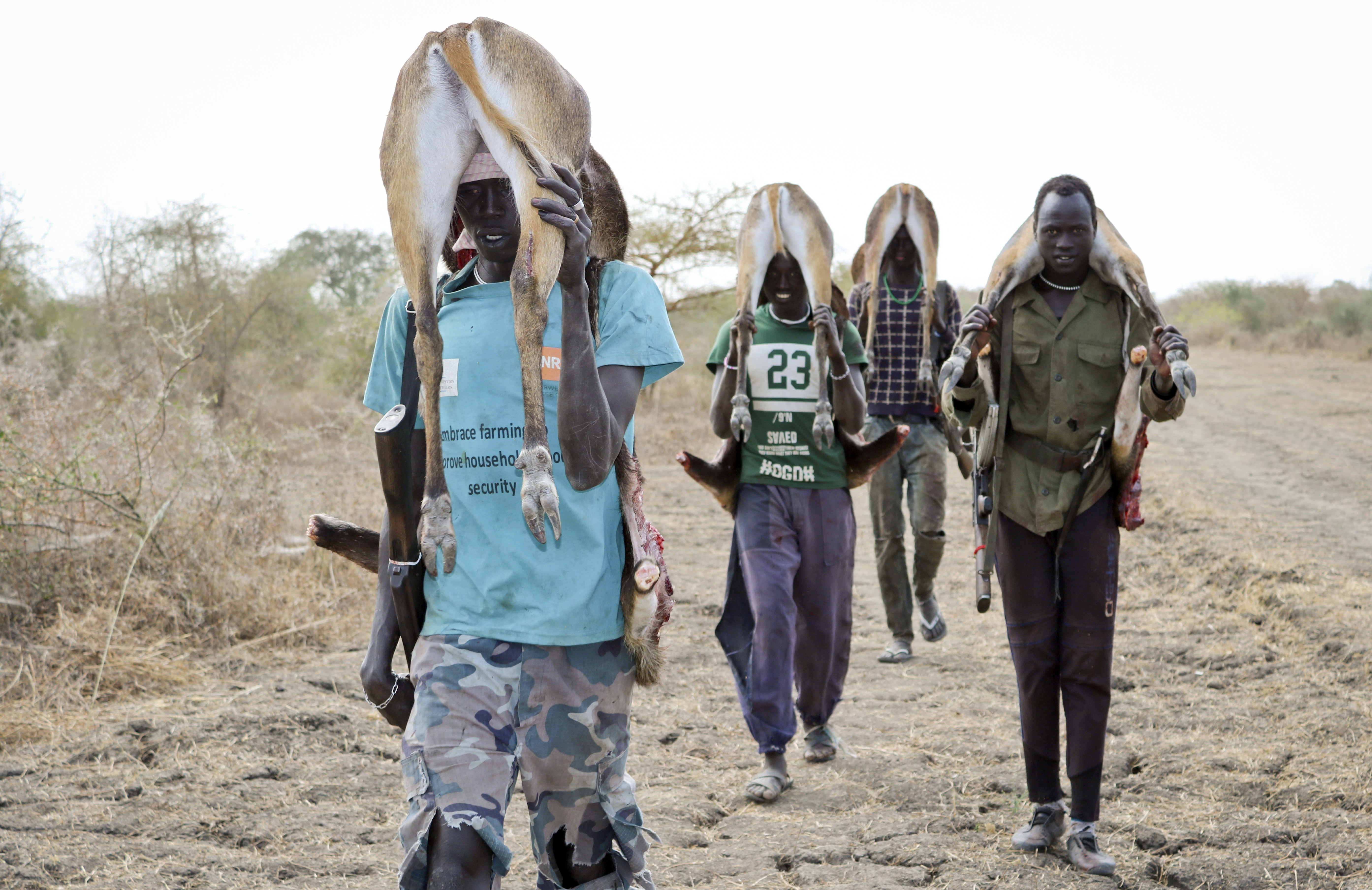 In this photo taken Wednesday, Jan. 24, 2018, men return from the bush after hunting gazelle to sell at the market in Akobo town, one of the last rebel-held strongholds in South Sudan. South Sudan's opposition is threatening to resort to 