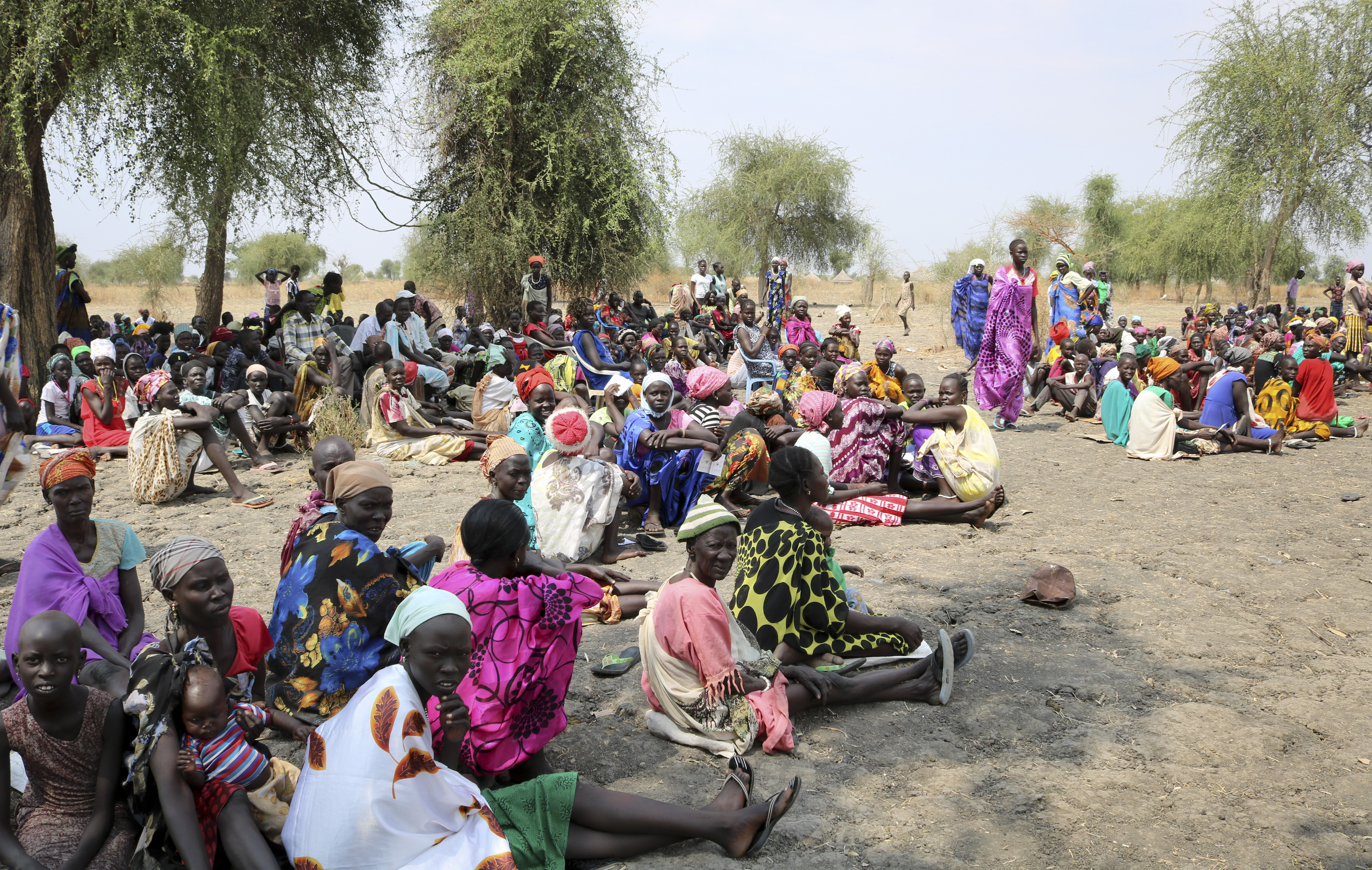 In this photo taken Saturday, Jan. 20, 2018, people wait for food handouts at an Oxfam distribution taking place outside of Akobo town, one of the last rebel-held strongholds in South Sudan. South Sudan's opposition is threatening to resort to 