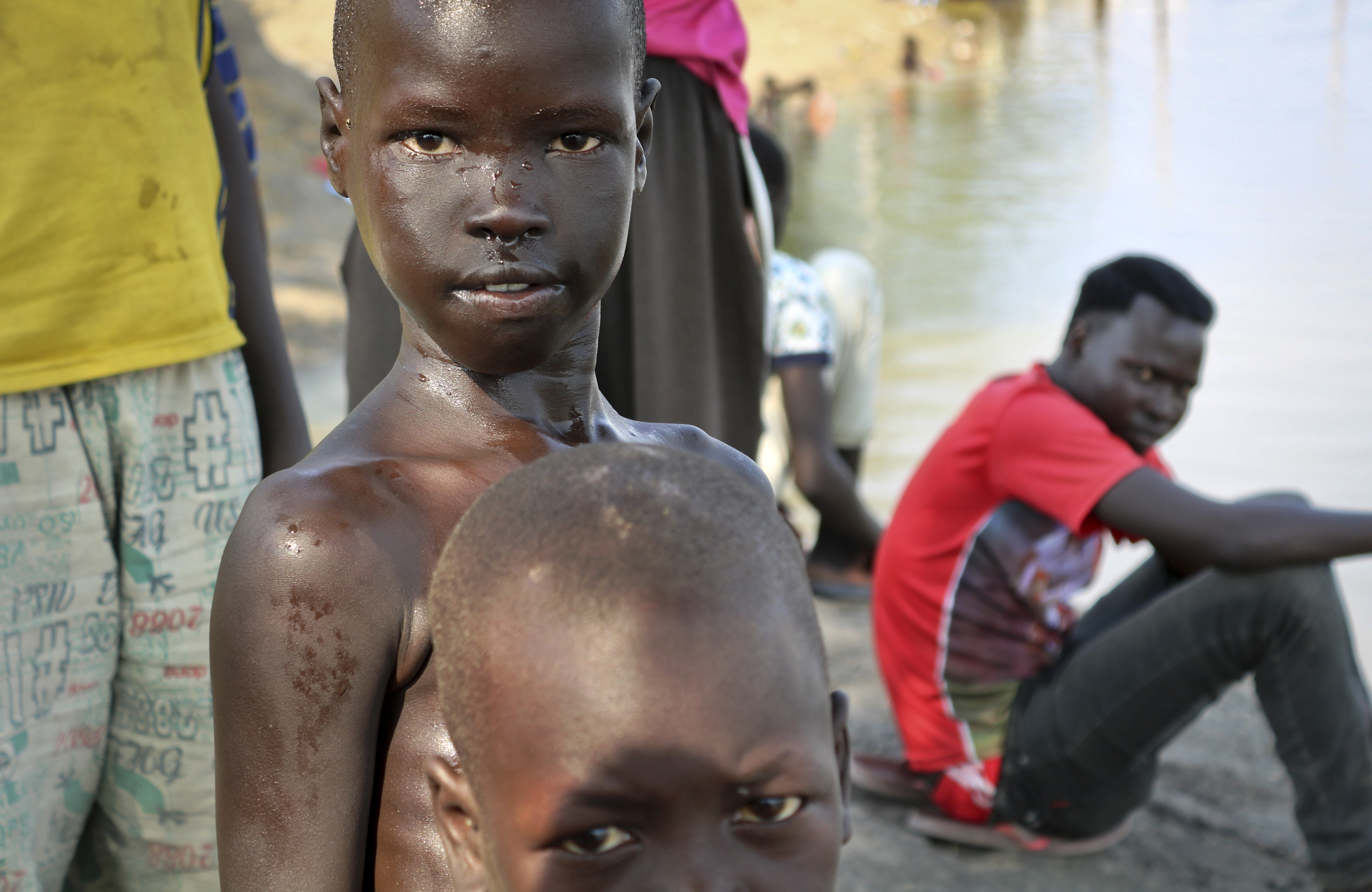 In this photo taken Thursday, Jan. 18, 2018, a boy comes out of the water after going for a swim in the Nile in Akobo town, one of the last rebel-held strongholds in South Sudan. Child abductions have risen during South Sudan's civil war as desperate people try to make a living, and one child, no matter the age, is said to sell for 20 cows, worth about $7,000. (AP Photo/Sam Mednick)