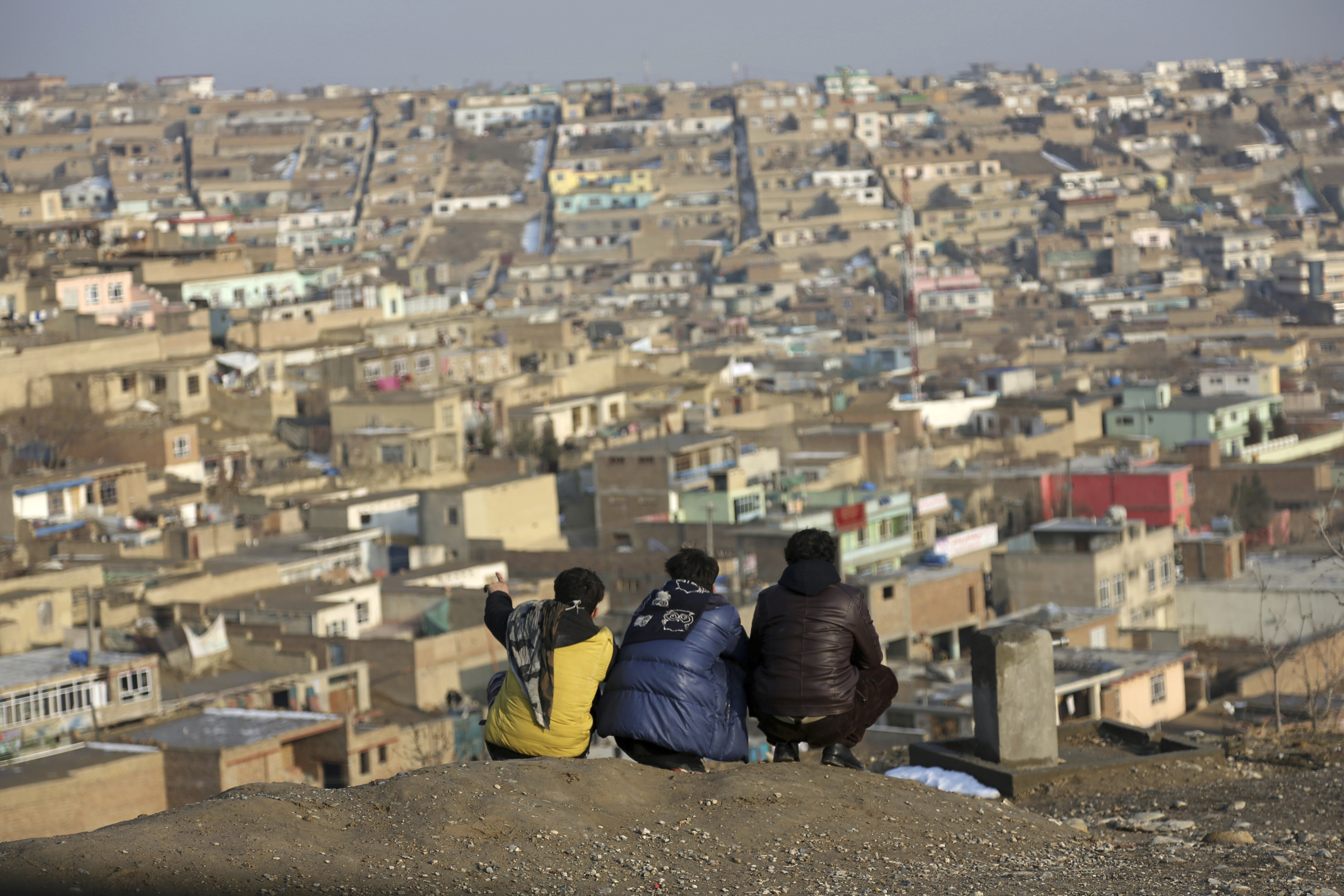 Afghan boys look over the city of Kabul, Afghanistan, Tuesday, Jan. 30, 2018. (AP Photo/Rahmat Gul)
