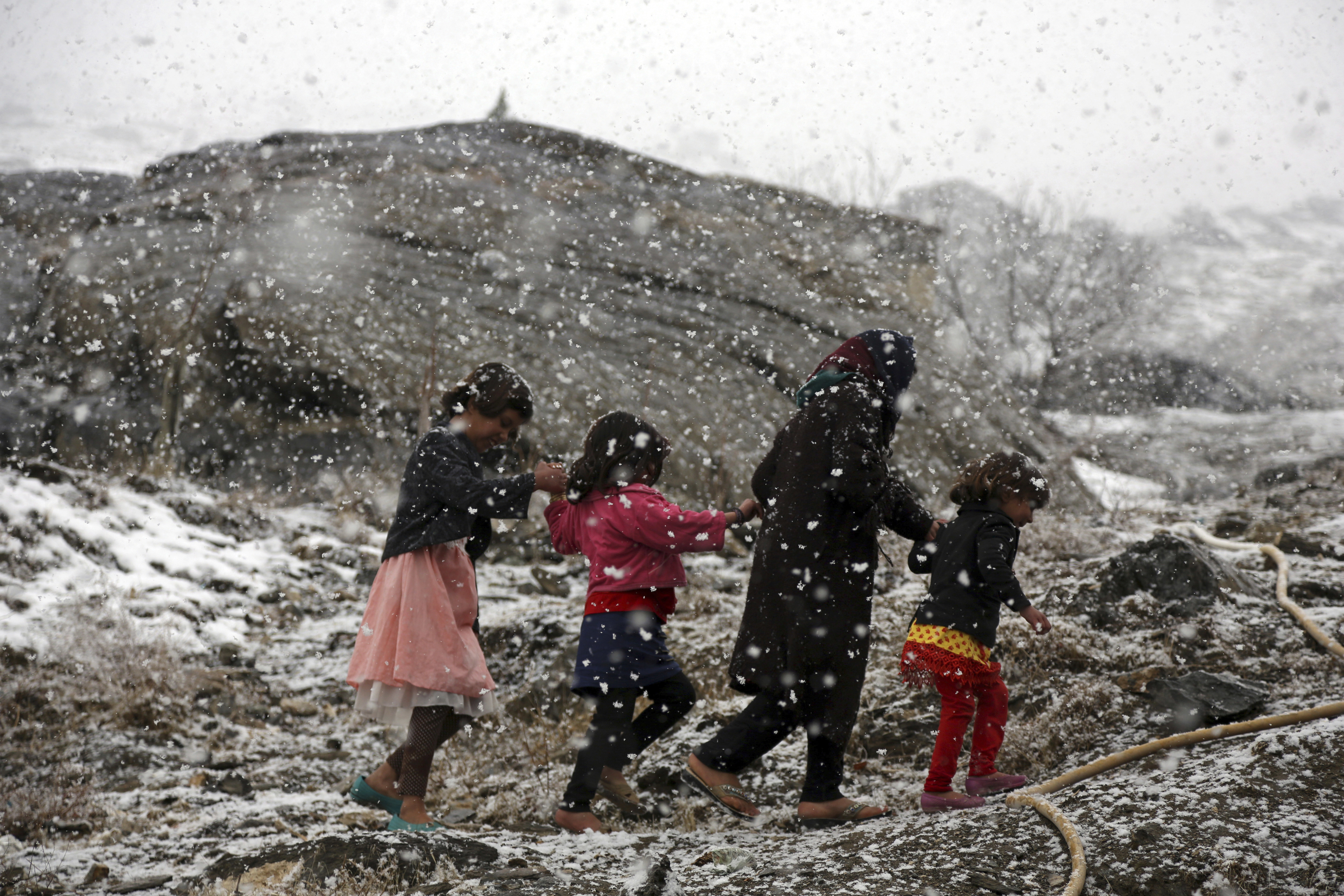 Afghan children walk during a snowfall on hill on the outskirts of Kabul, Afghanistan, Wednesday, Jan. 31, 2018. (AP Photo/Rahmat Gul)
