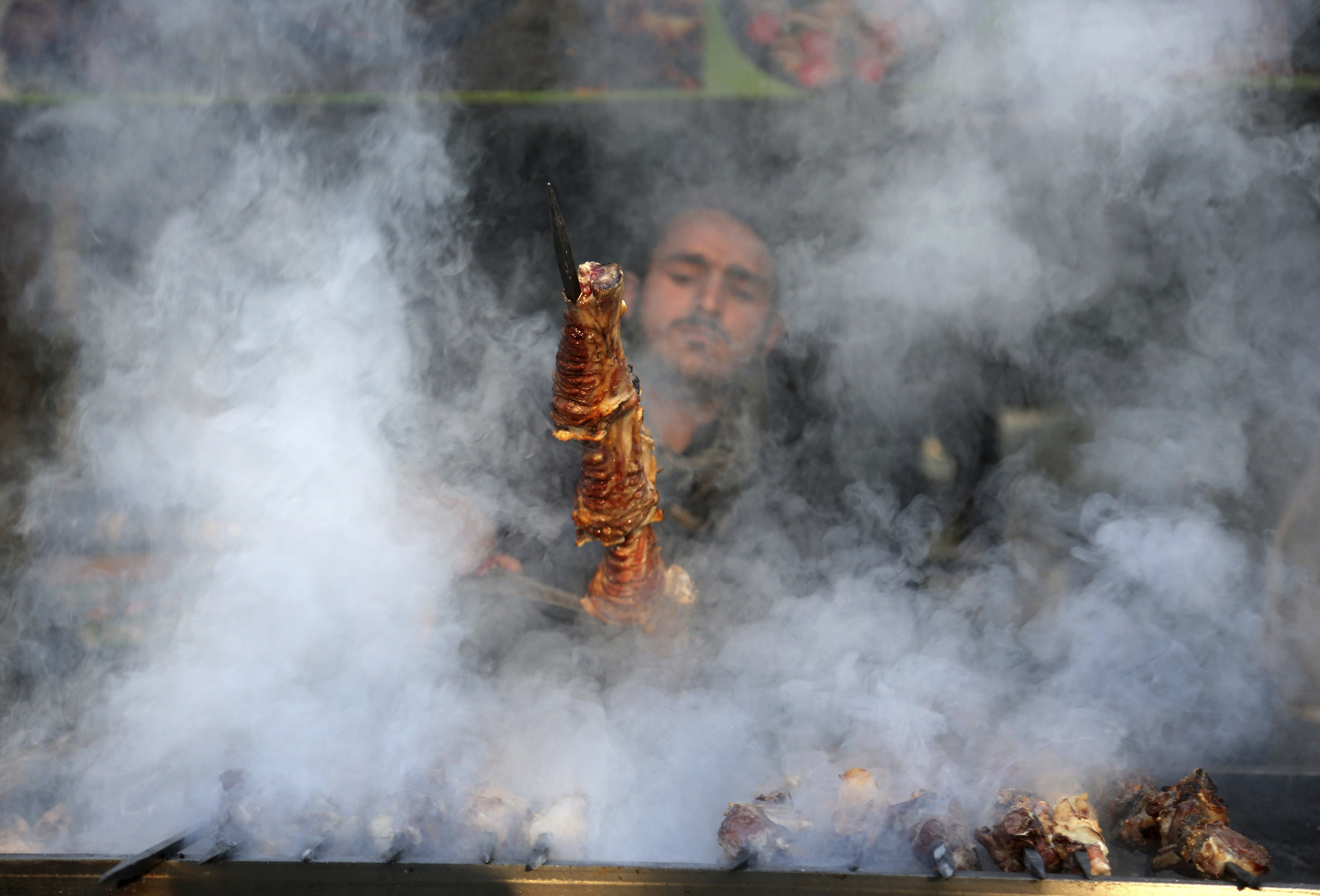 An Afghan man cooks Kabab at a restaurant in Kabul, Thursday, Feb. 8, 2018. (AP Photo/Rahmat Gul)