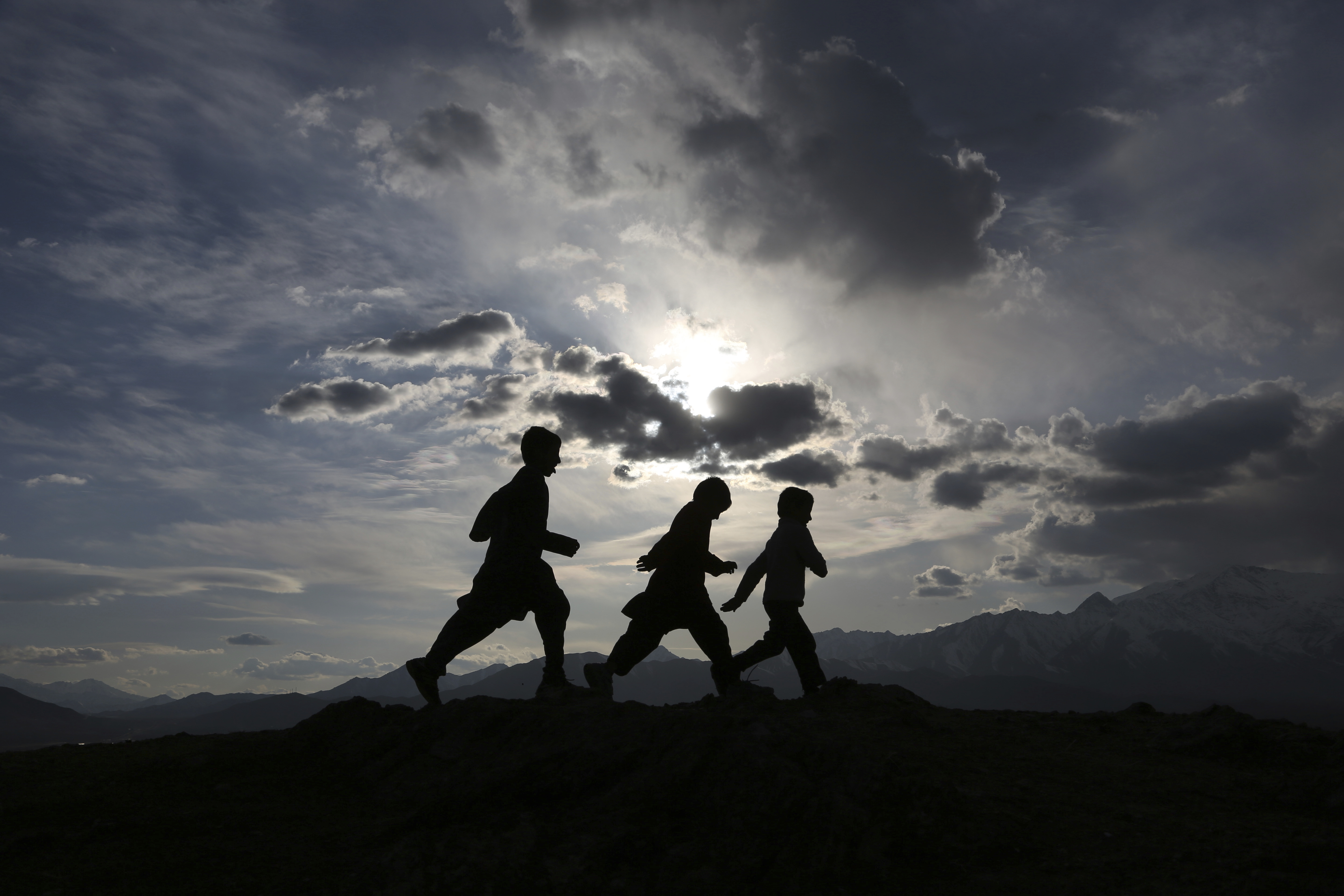 Afghan boys play at sunset on hilltop on the the outskirts of Kabul, Sunday, March, 4, 2018. (AP Photo/Rahmat Gul)