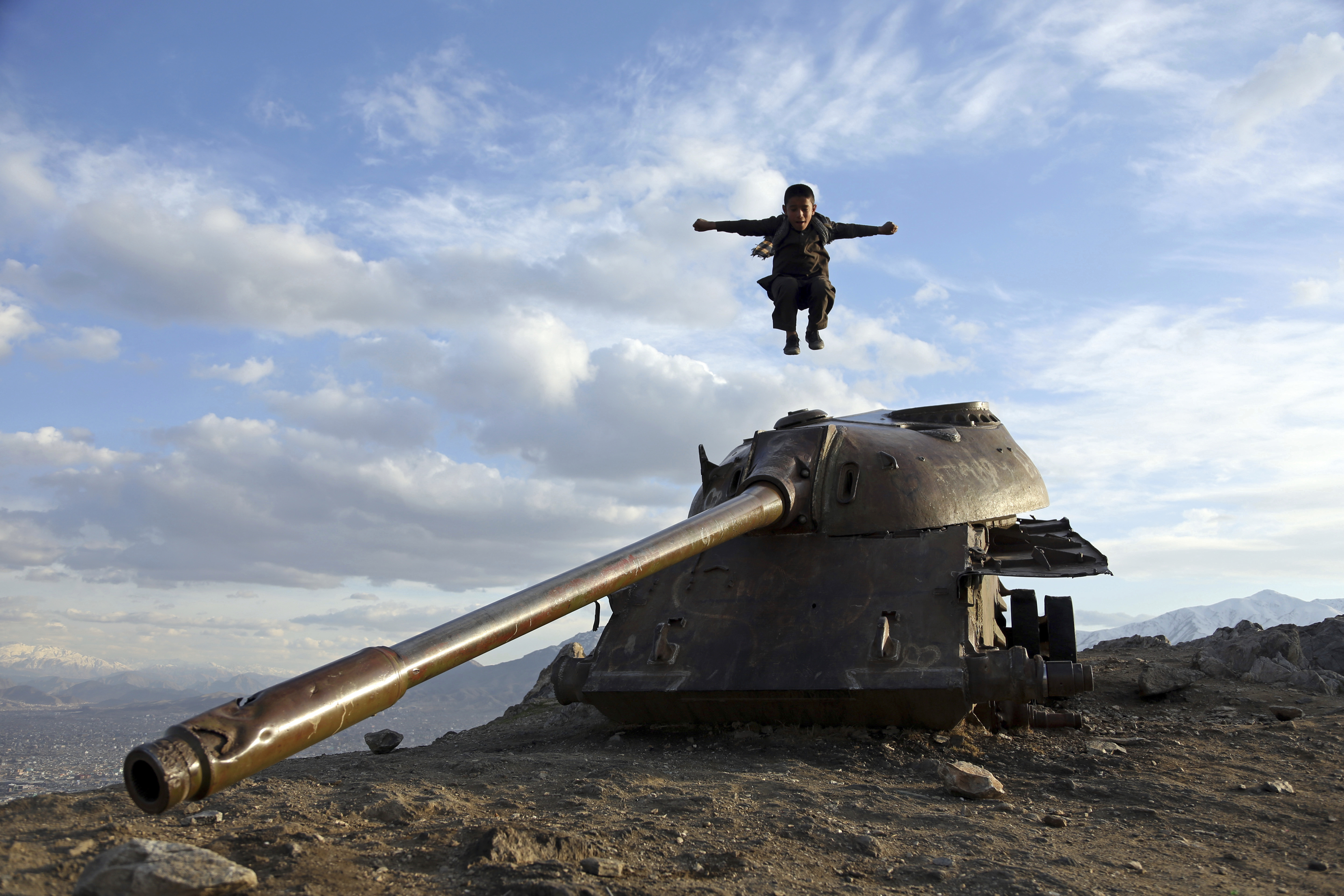 An Afghan boy jumps off the turret of a Soviet tank on a hilltop on the the outskirts of Kabul, Sunday, March, 4, 2018. (AP Photo/Rahmat Gul)