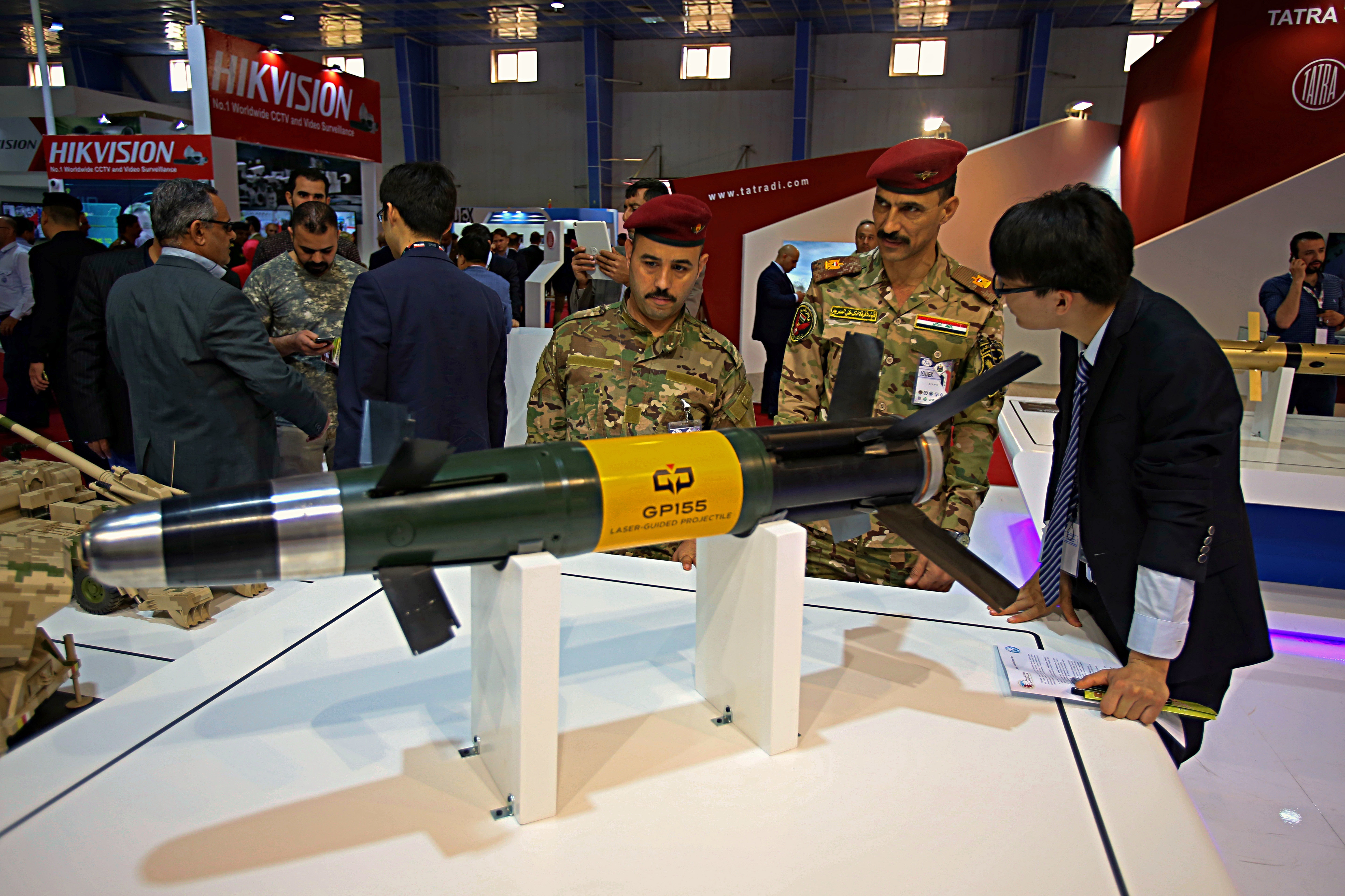 Visitors attending the seventh annual weapons exhibition organized by the Iraqi ministry of defense look at a laser guided projectile, at the Baghdad International Fairgrounds, Sunday, March, 11, 2018. (AP Photo/Karim Kadim)