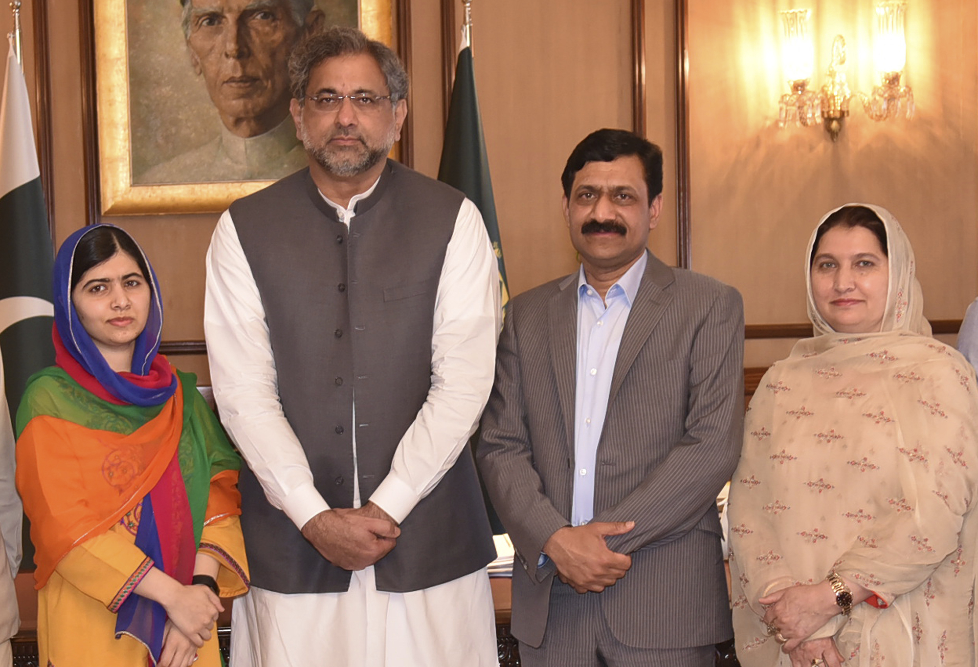 In this photo released by the Press Information Department, Pakistani Nobel Peace Prize winner Malala Yousafzai, left, and her parents pose for a photograph with Shahid Khaqan Abbasi, second from left, Prime Minister of Pakistan in Islamabad, Pakistan, Thursday, March 29, 2018. Yousafzai on Thursday said she was excited to be back in Pakistan for the first time since she was shot in 2012 by Taliban militants angered at her championing of education for girls. (Press Information Department via AP)