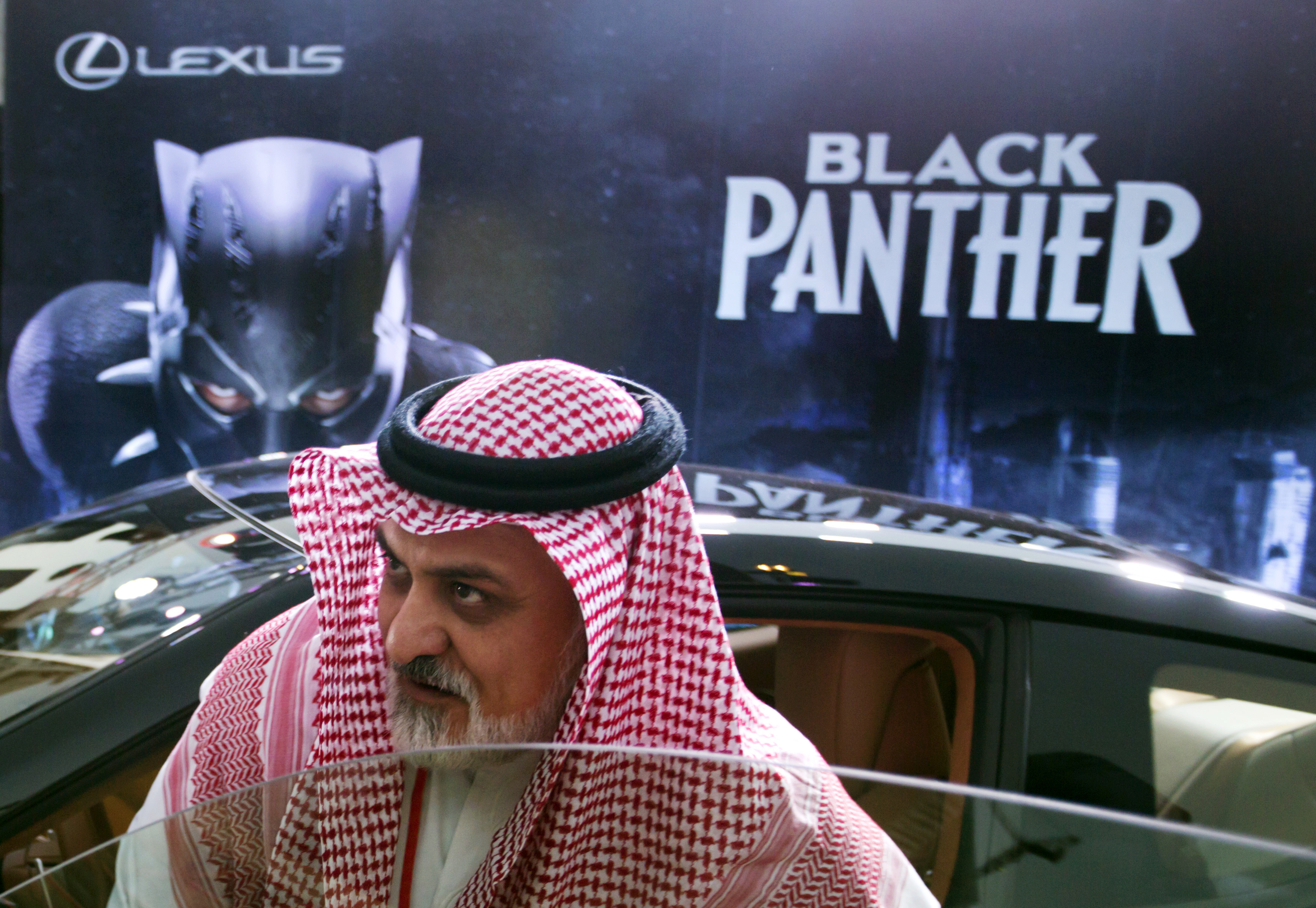 A visitor checks out a Lexus car, similar to a one used in the Black Panther film, that is on display outside an invitation-only screening, at the King Abdullah Financial District Theater, in Riyadh, Saudi Arabia, Wednesday, April 18, 2018. Saudi Arabia held a private screening of the Hollywood blockbuster 