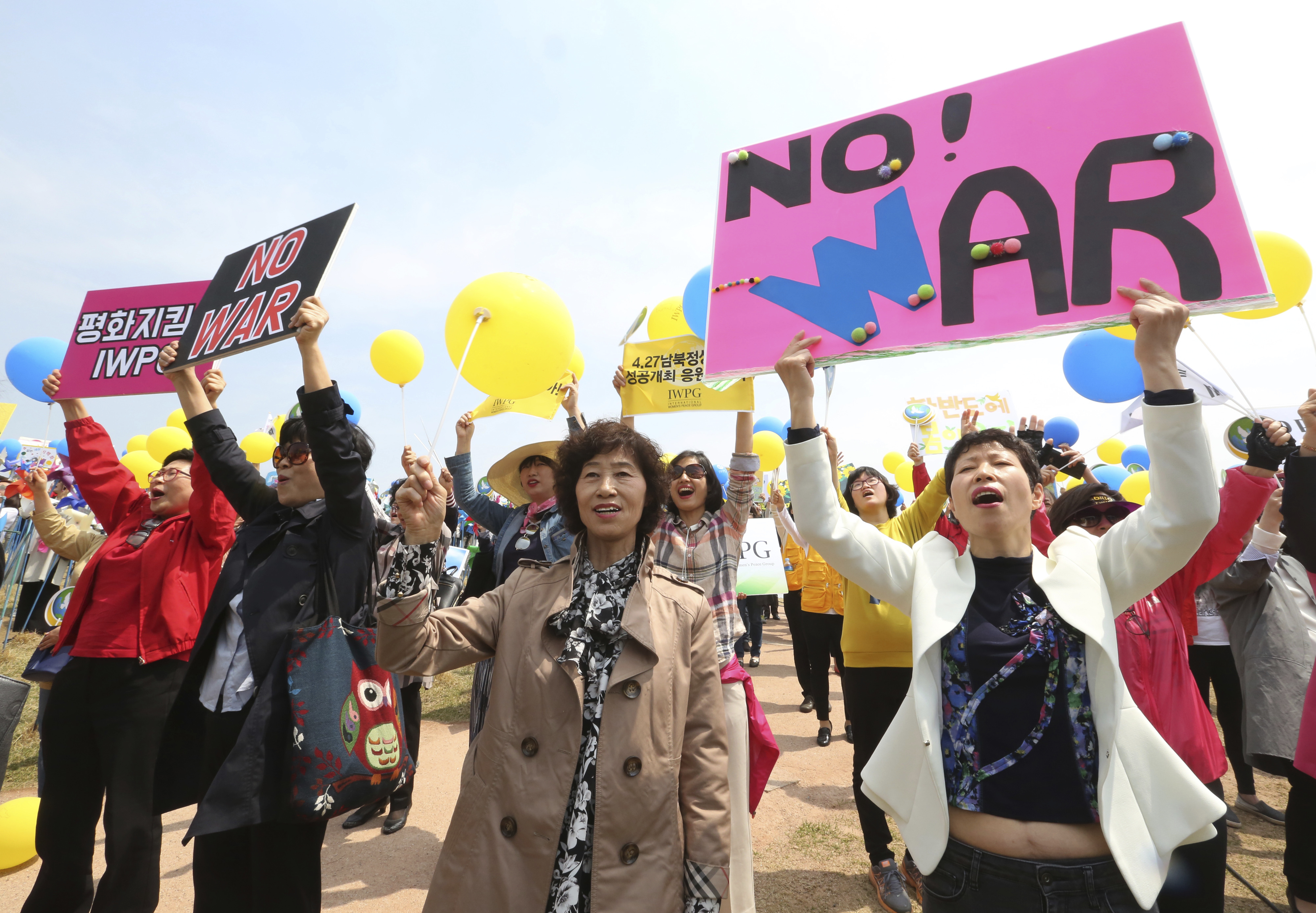 Members of the South Korean women's peace group stage a rally to support the upcoming summit between South and North Korea at the Imjingak Pavilion in Paju, South Korea, near the border with North Korea, Thursday, April 26, 2018. North Korean leader Kim Jong Un and South Korean President Moon-Jae-in will plant a commemorative tree and inspect an honor guard together after Kim walks across the border Friday for their historic summit, Seoul officials said Thursday. (AP Photo/Ahn Young-joon)