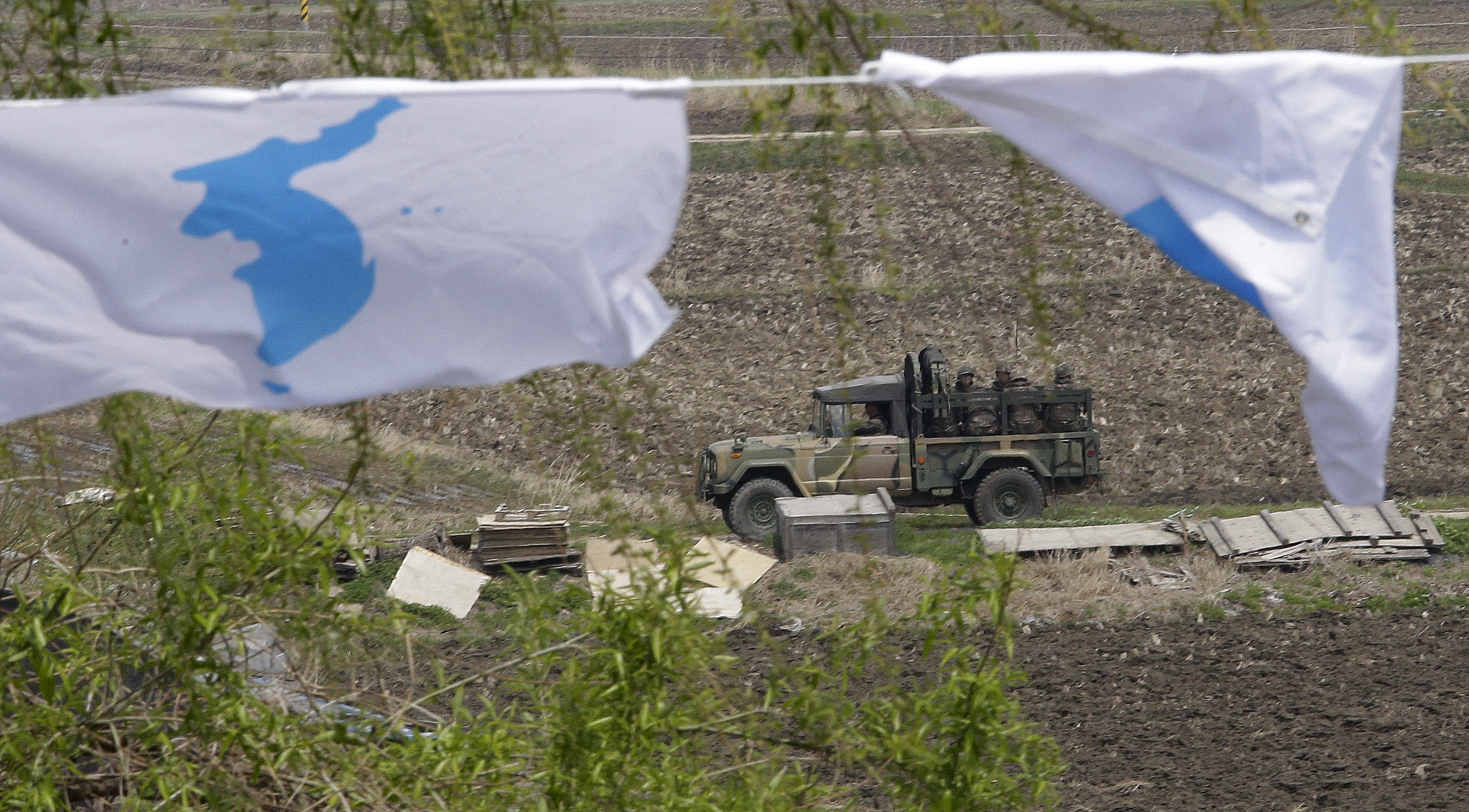 A South Korean military vehicle passes by unification flags near Unification Bridge, which leads to the Panmunjom in Paju, South Korea, Thursday, April 26, 2018. North Korean leader Kim Jong Un and South Korean President Moon-Jae-in will plant a commemorative tree and inspect an honor guard together after Kim walks across the border Friday for their historic summit, Seoul officials said Thursday. (AP Photo/Ahn Young-joon)