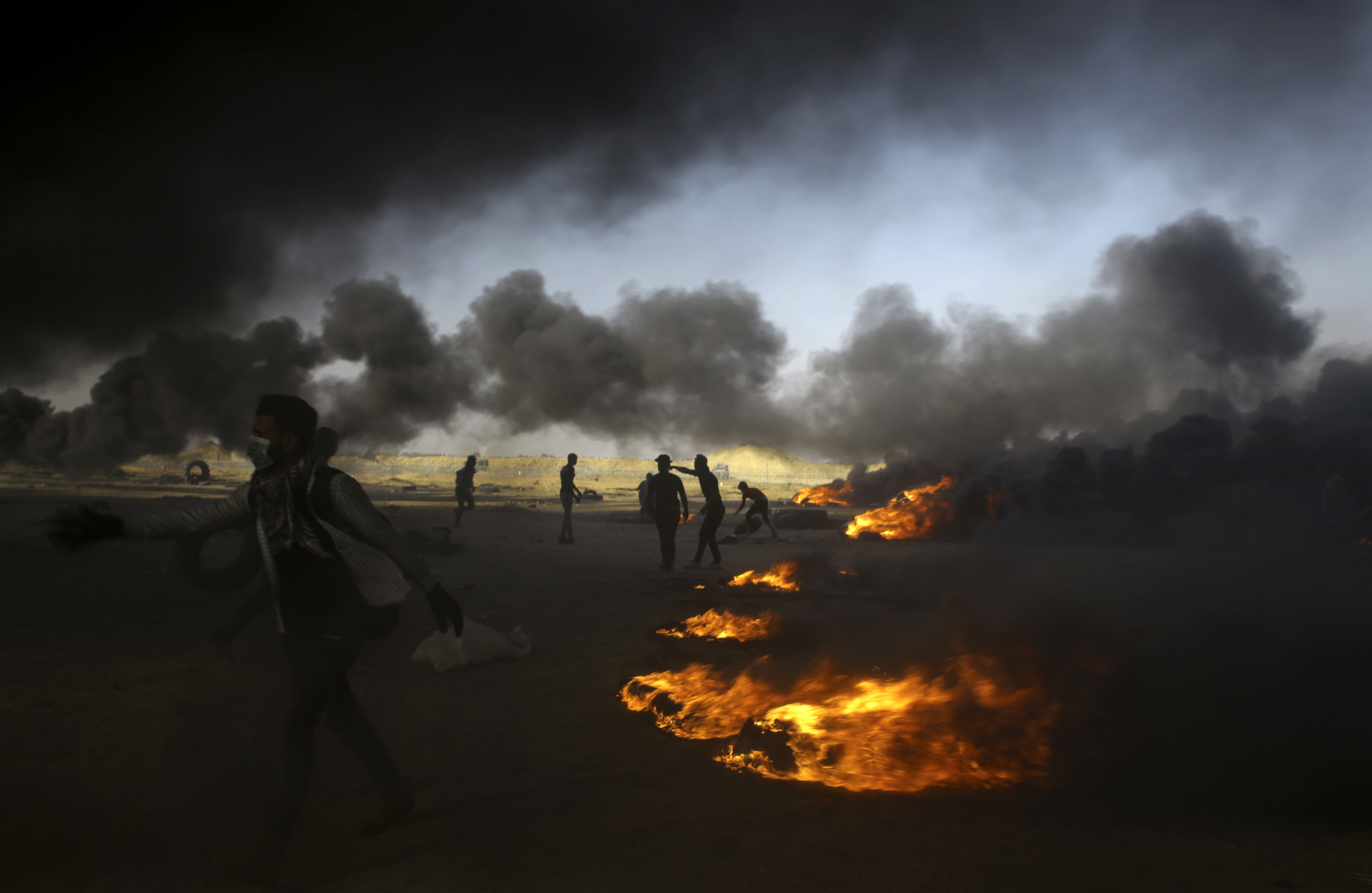 Palestinian protesters burn tires during a protest at the Gaza Strip's border with Israel, east of Khan Younis, Tuesday, May 15, 2018. Israel faced a growing backlash Tuesday and new charges of using excessive force, a day after Israeli troops firing from across a border fence killed dozens of Palestinians and wounded more than 2,700 at a mass protest in Gaza. (AP Photo/Adel Hana)