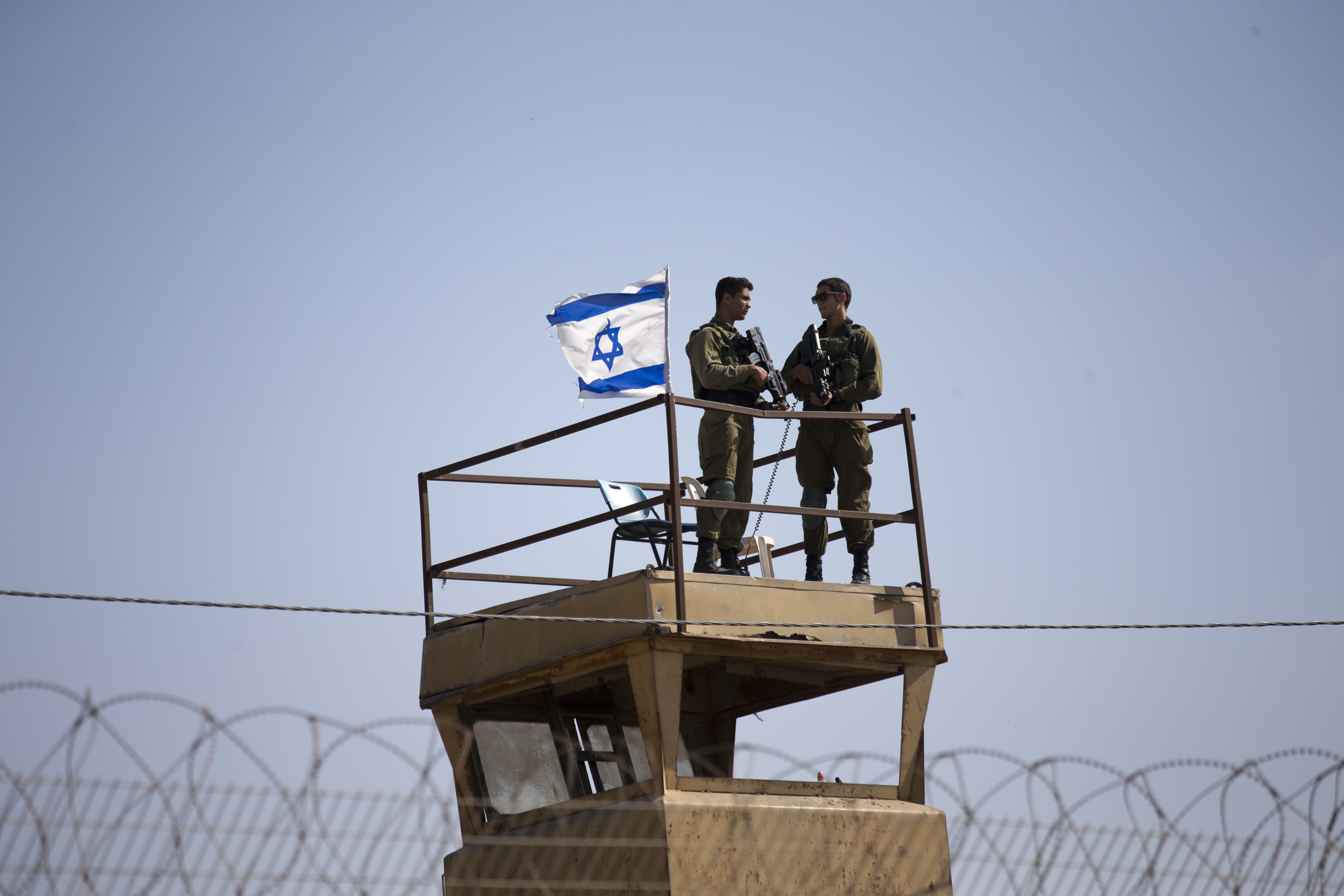 Israeli soldiers guard on top of a watch tower in a community along the Israel- Gaza Strip Border, Tuesday, May 15, 2018.  Thousands joined funeral processions Tuesday for some of the dozens of Palestinians killed by Israeli troops in a mass march on the Gaza border, as Israelis faced growing diplomatic fallout from the use of lethal force against unarmed protesters.(AP Photo/Ariel Schalit)