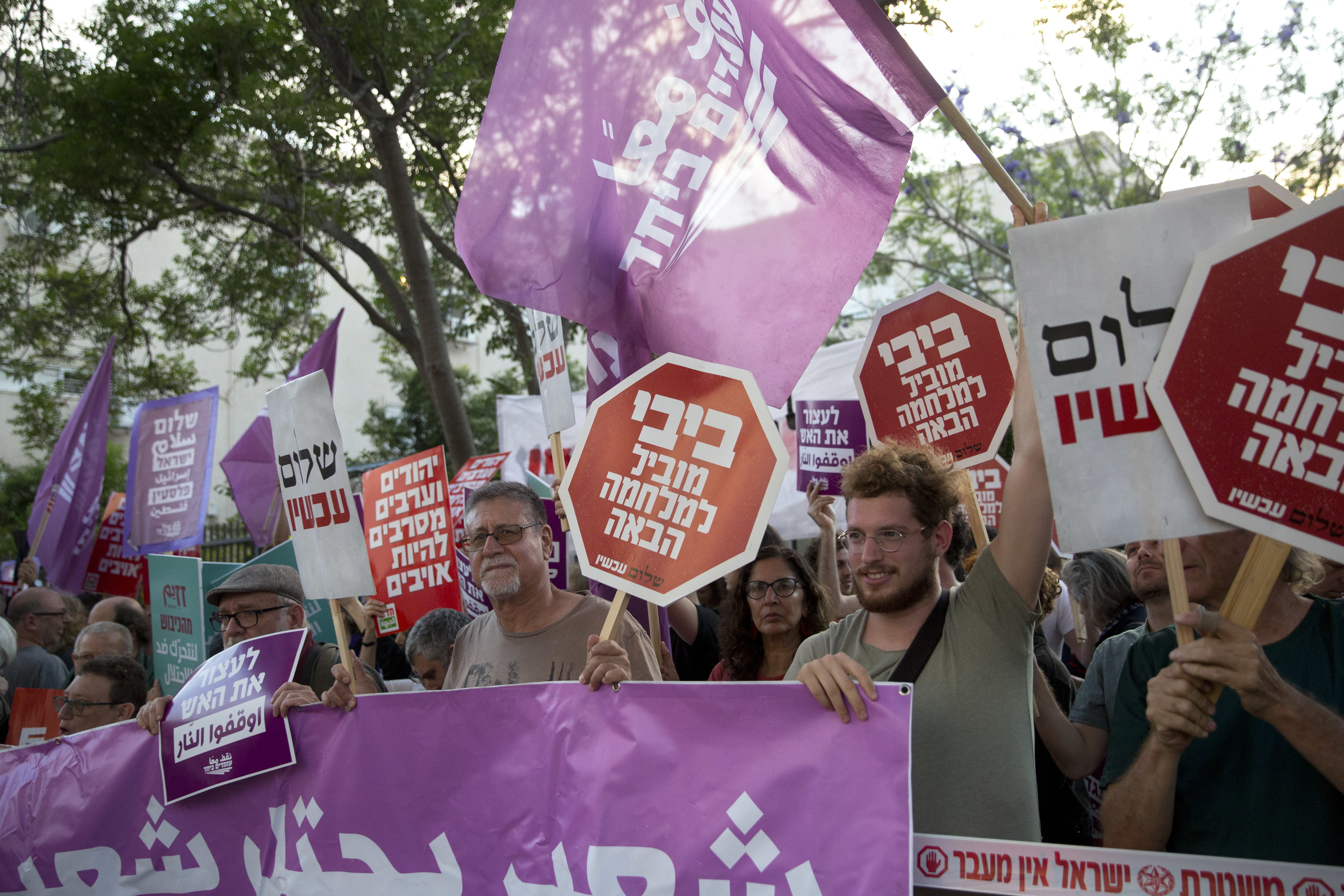Left-wing Israelis hold signs during a demonstration against the situation in Gaza in Tel Aviv, Israel, Tuesday, May 15, 2018. Israel faced a growing backlash Tuesday and new charges of using excessive force, a day after Israeli troops firing from across a border fence killed 59 Palestinians and wounded more than 2,700 at a mass protest in Gaza. Hebrew sign reads: 