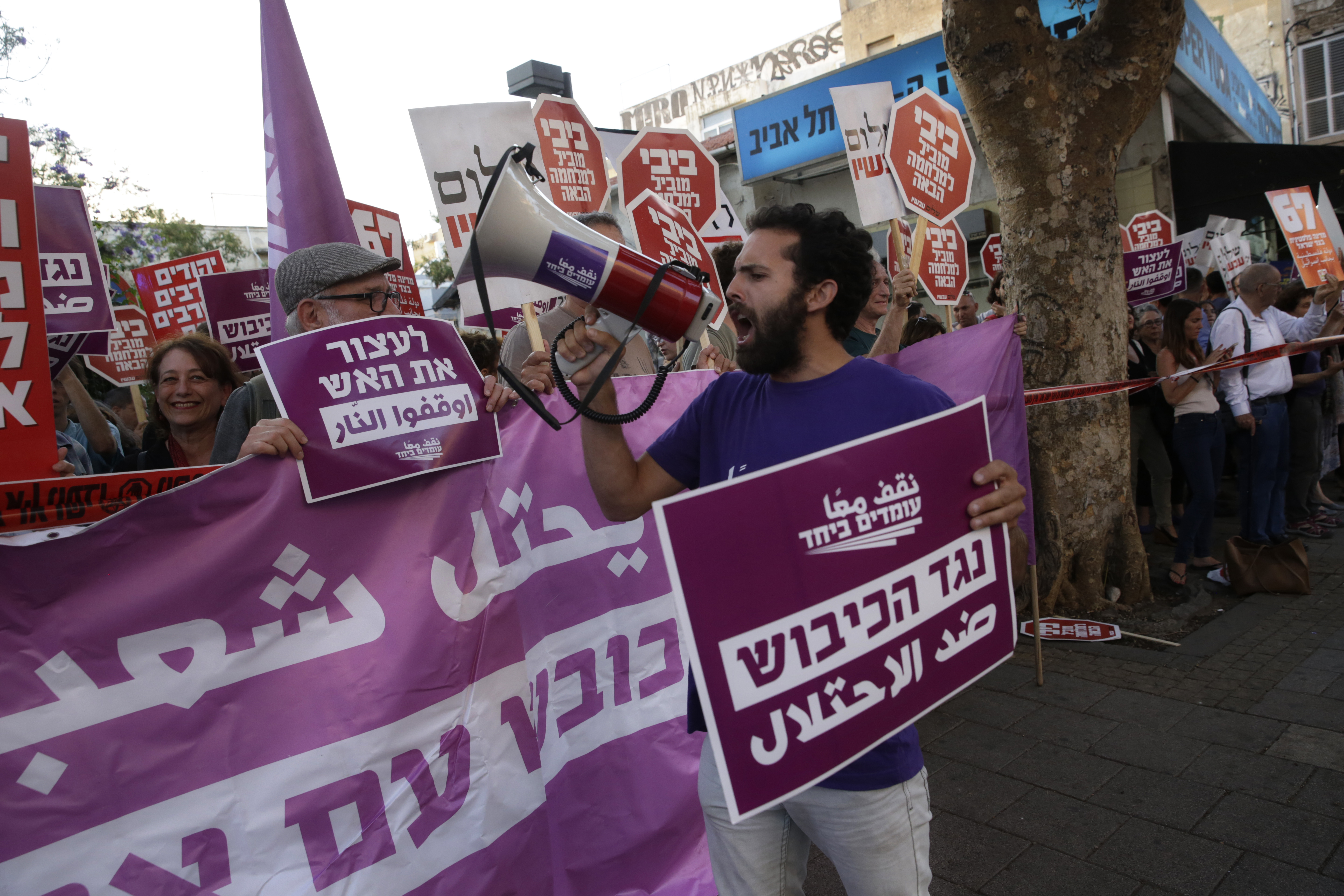 Left-wing Israelis hold signs during a demonstration against the situation in Gaza in Tel Aviv, Israel, Tuesday, May 15, 2018. Israel faced a growing backlash Tuesday and new charges of using excessive force, a day after Israeli troops firing from across a border fence killed 59 Palestinians and wounded more than 2,700 at a mass protest in Gaza. Hebrew signs read: 