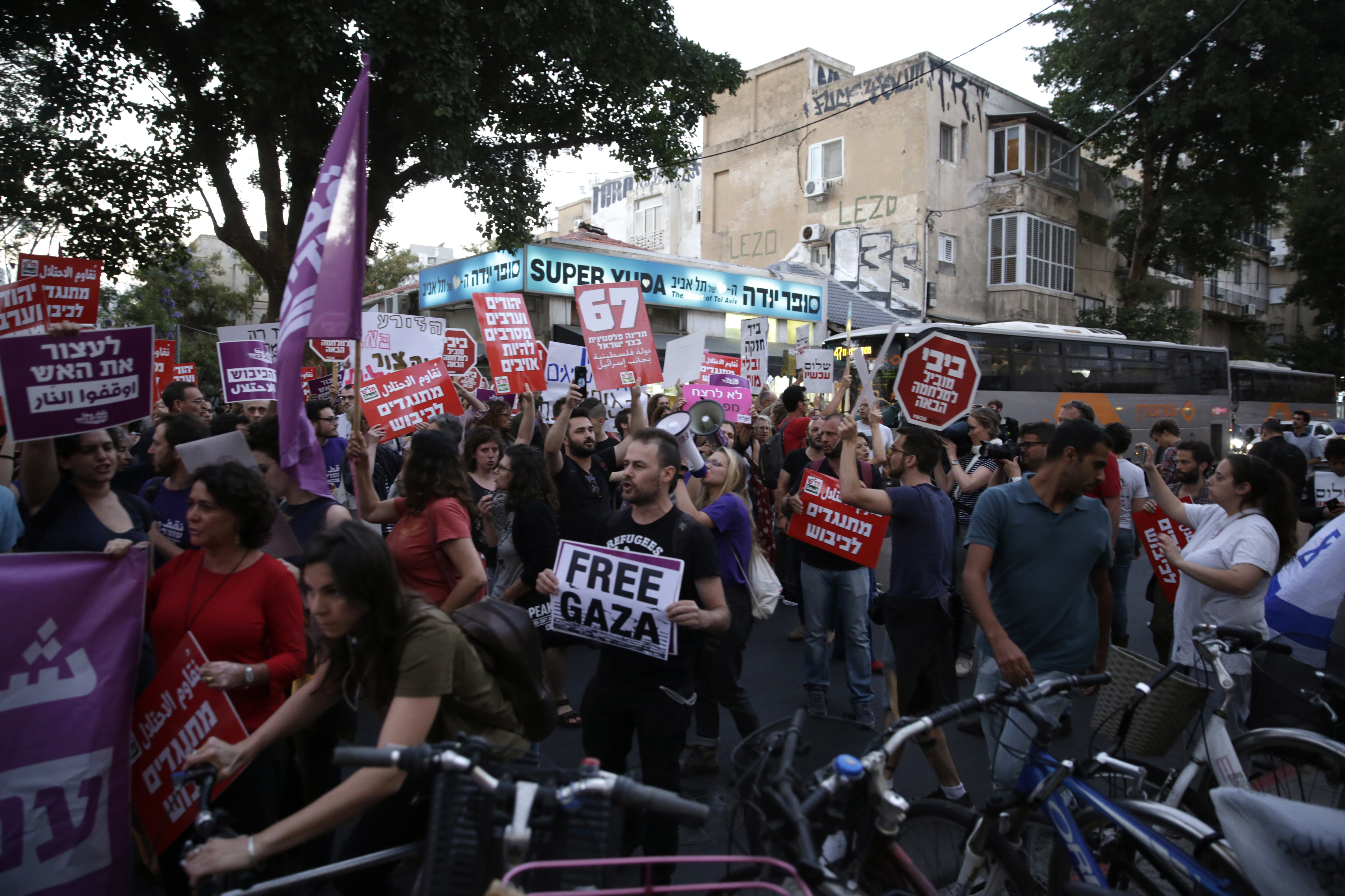 Left wing Israelis hold signs during a demonstration against the situation in Gaza in Tel Aviv, Israel, Tuesday, May 15, 2018. Israel faced a growing backlash Tuesday and new charges of using excessive force, a day after Israeli troops firing from across a border fence killed 59 Palestinians and wounded more than 2,700 at a mass protest in Gaza. (AP Photo/Sebastian Scheiner)