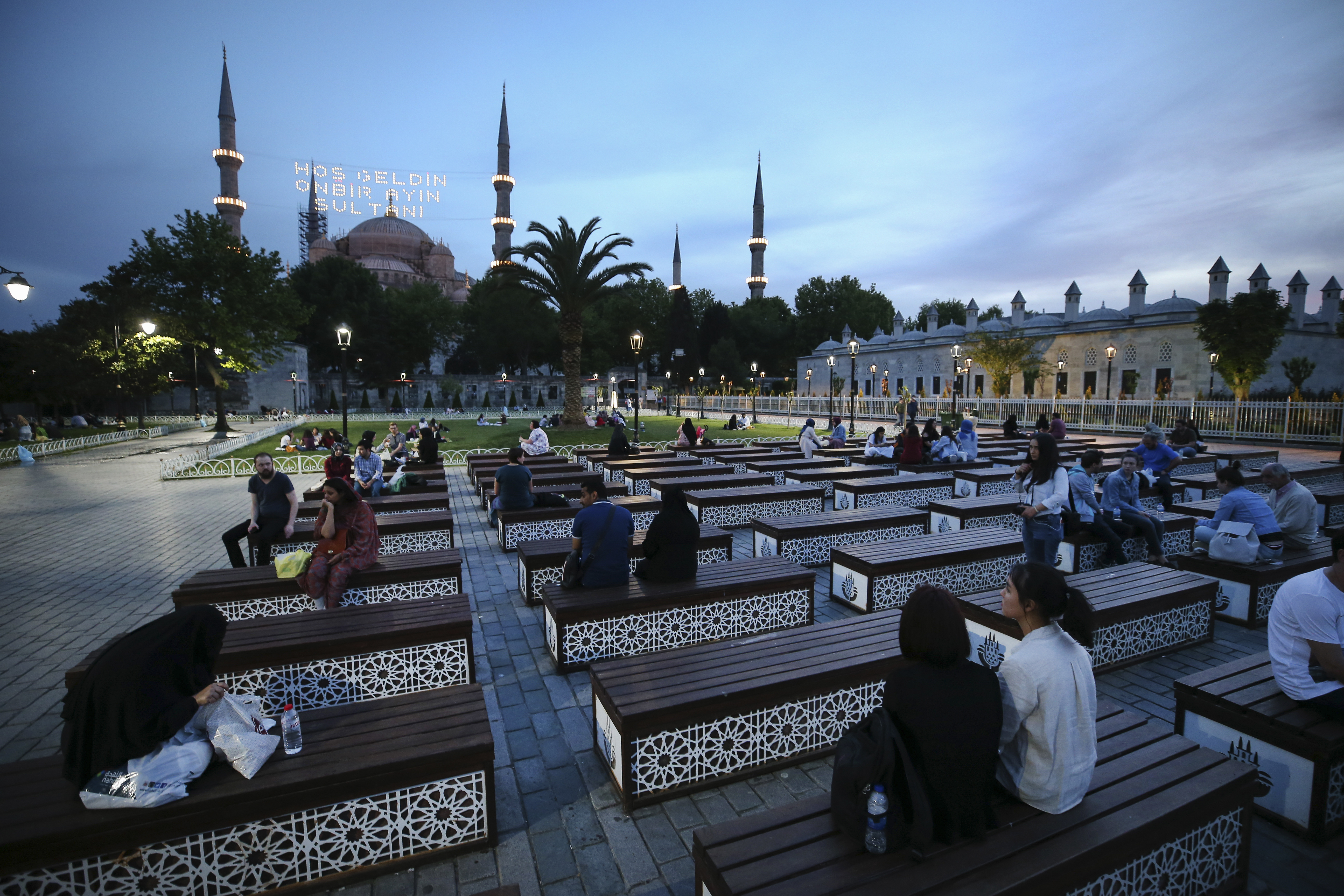 Backdropped by the iconic Sultan Ahmed Mosque, better known as the Blue Mosque, people break their fast in the historic Sultanahmet district of Istanbul, Saturday, May 27, 2017 on the first day of the fasting month of Ramadan. The lights read in Turkish: 'Welcome, the Sultan of 11 months'. Muslims throughout the world are marking Ramadan - a month of fasting during which the observants abstain from food, drink and other pleasures from sunrise to sunset. After an obligatory sunset prayer, a large feast known as 'iftar' is shared with family and friends. (AP Photo/Emrah Gurel)