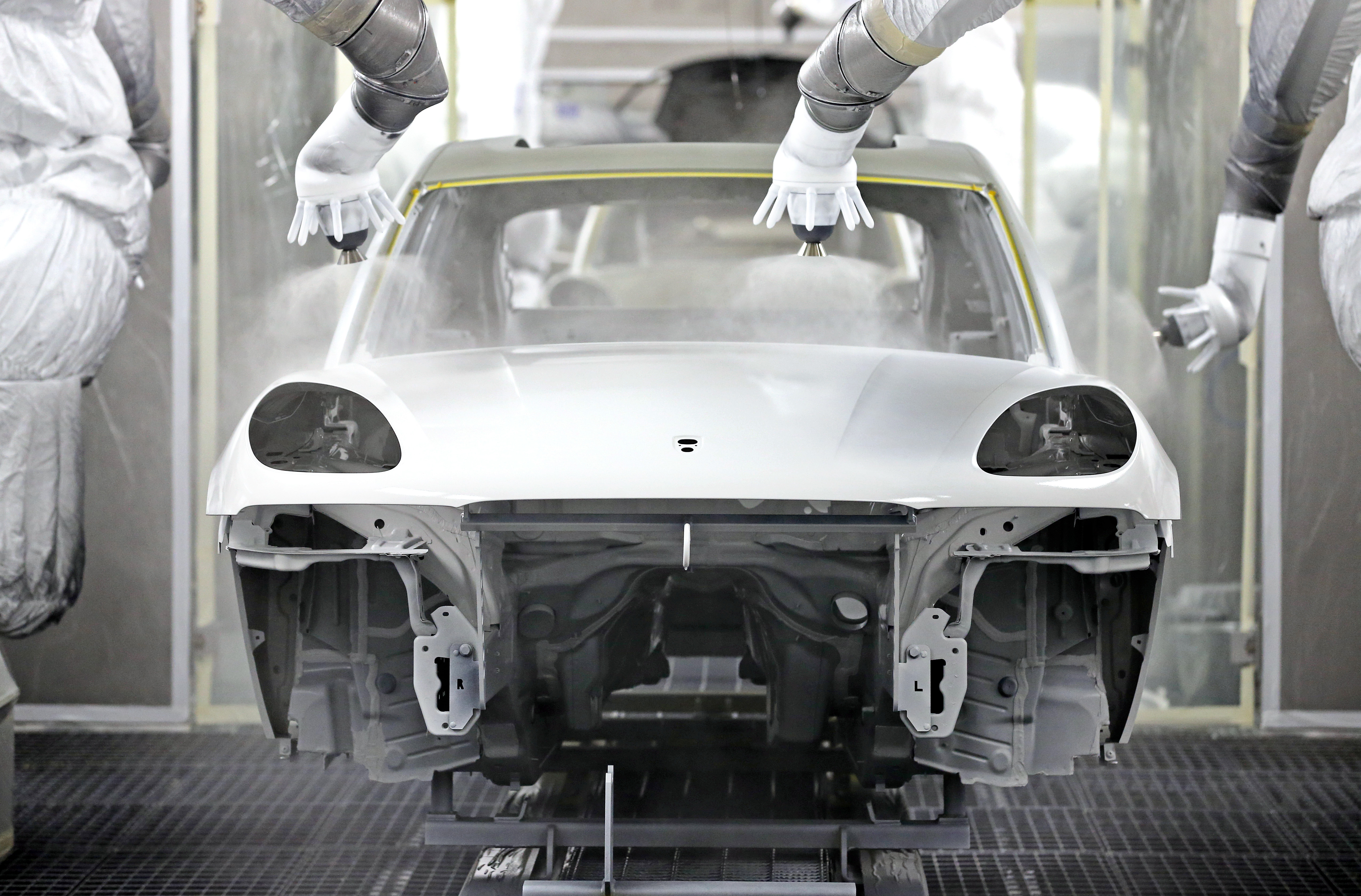 Industrial robots paint the bodywork of a new Porsche Macan at the Porsche plant in Leipzig, Germany, 05 February 2014. Car manufacturer Porsche will officially open its new Macan factory on 11 February 2014. Porsche invested 500 million euros in the expansion of its east German production location, creating 1,500 jobs. Photo by: Jan Woitas/picture-alliance/dpa/AP Images