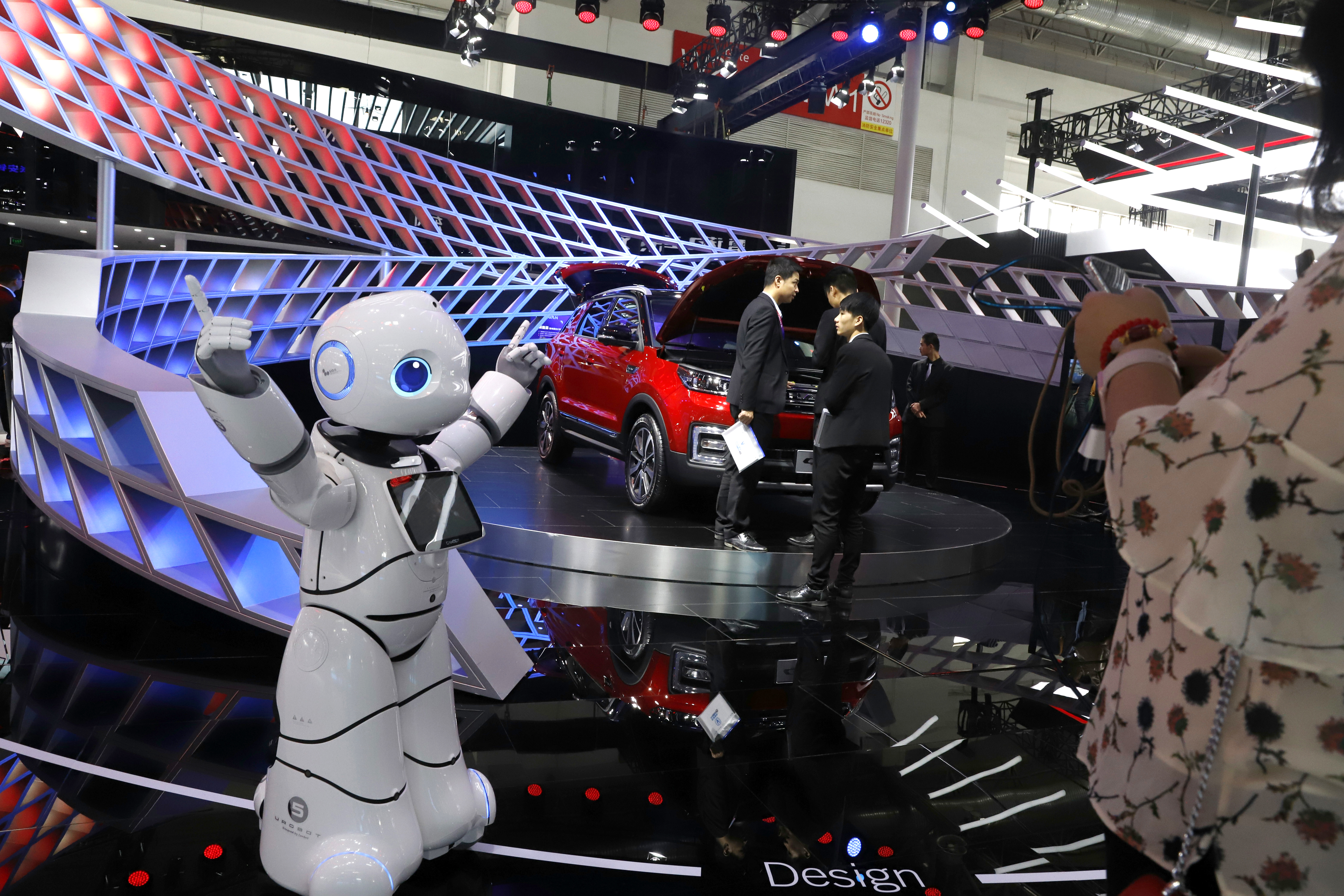 In this April 26, 2018, photo, a robot entertains visitors at the booth of a Chinese automaker during the China Auto 2018 show in Beijing, China. Under President Xi Jinping, a program known as 