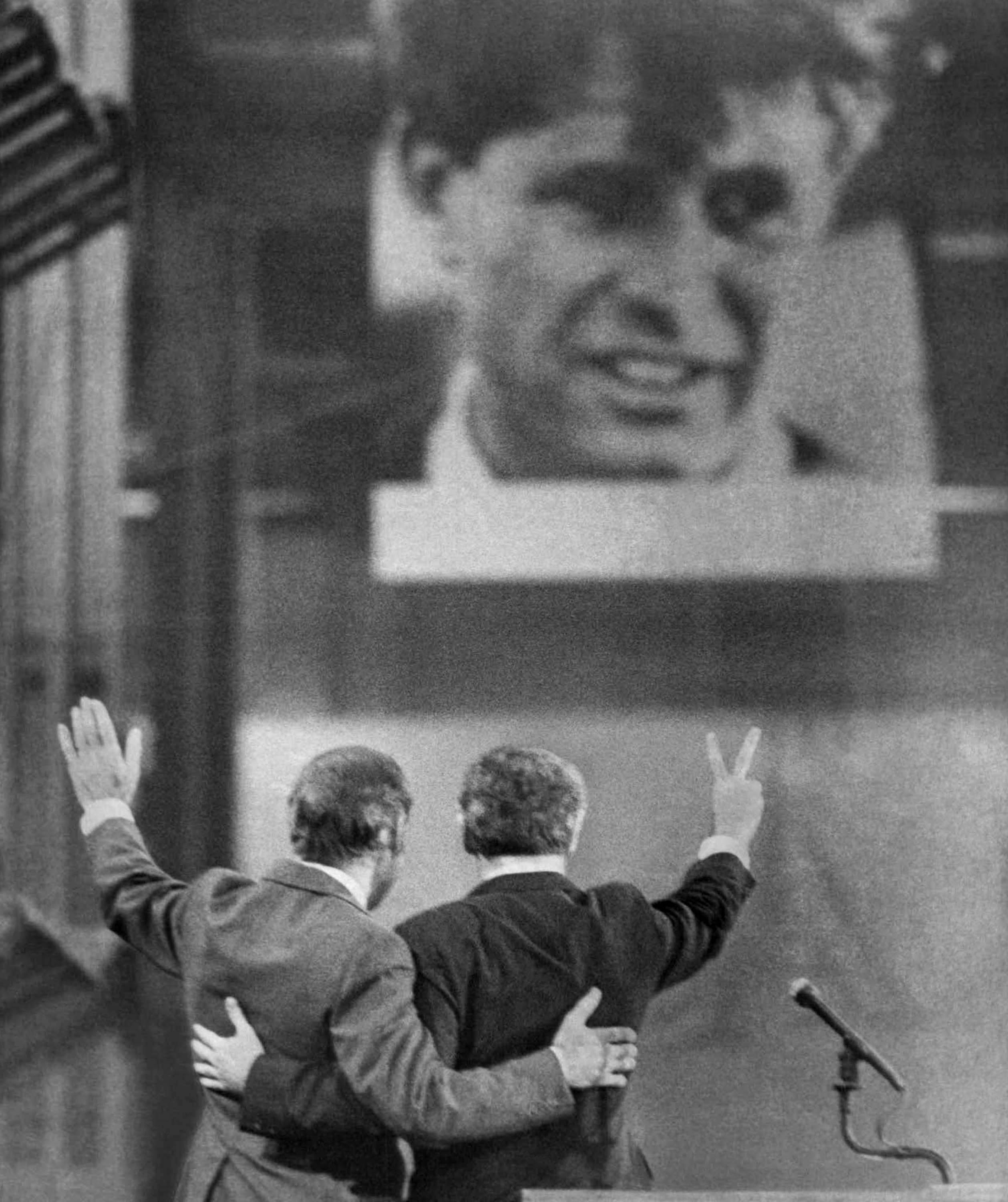 A massive portrait of the late Sen. Robert F. Kennedy looks down on the Democratic National Convention early Friday July 14, 1972 as Sen. George S. McGovern, left, and Sen. Thomas F. Eagleton wave to the delegates campaign in Miami Beach. (AP Photo/BobDaugherty )