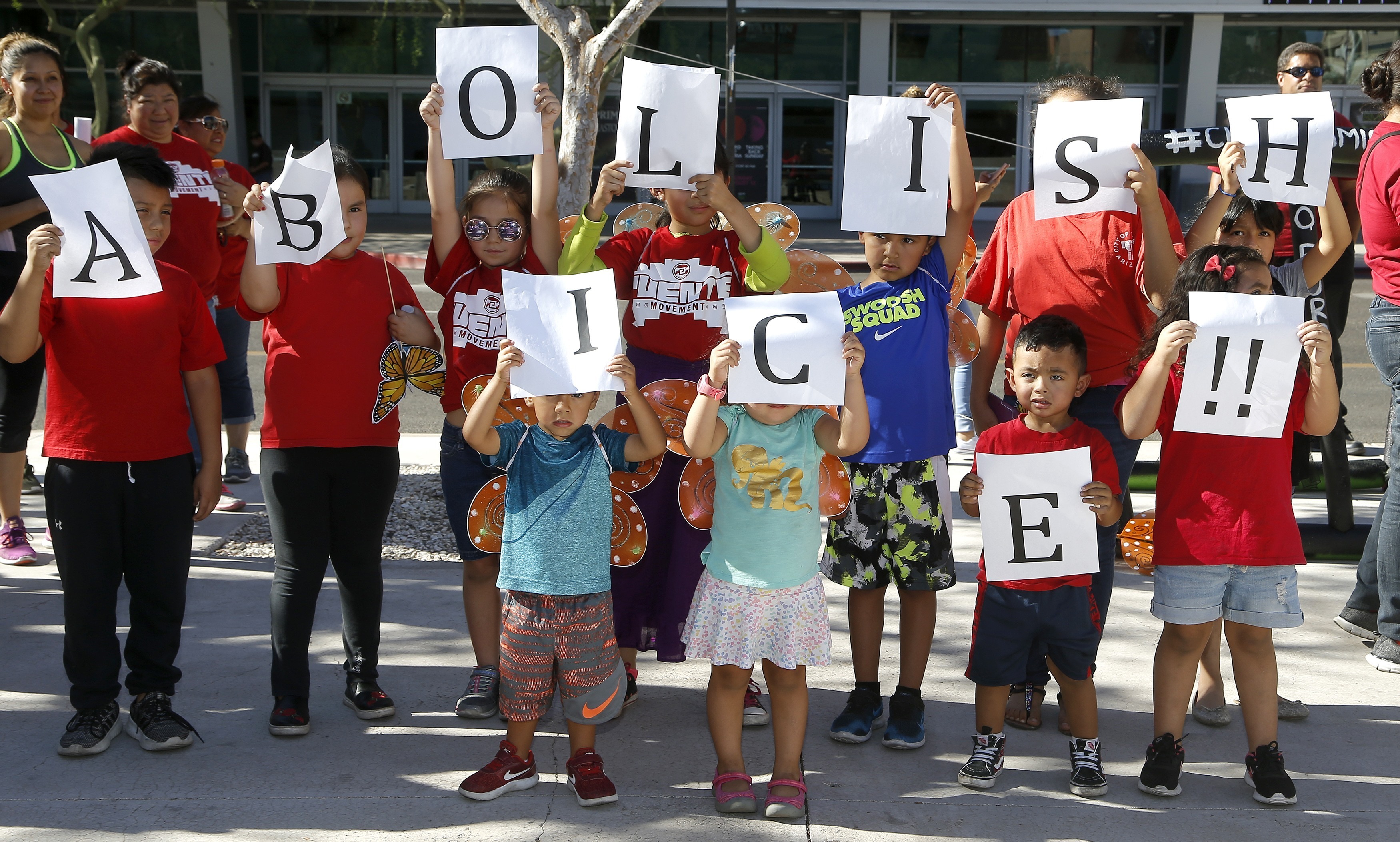 Kids hold up signs during an immigration family separation protest in front of the Sandra Day O'Connor U.S. District Court building, Monday, June 18, 2018, in Phoenix. An unapologetic President Donald Trump defended his administration's border-protection policies Monday in the face of rising national outrage over the forced separation of migrant children from their parents. (AP Photo/Ross D. Franklin)
