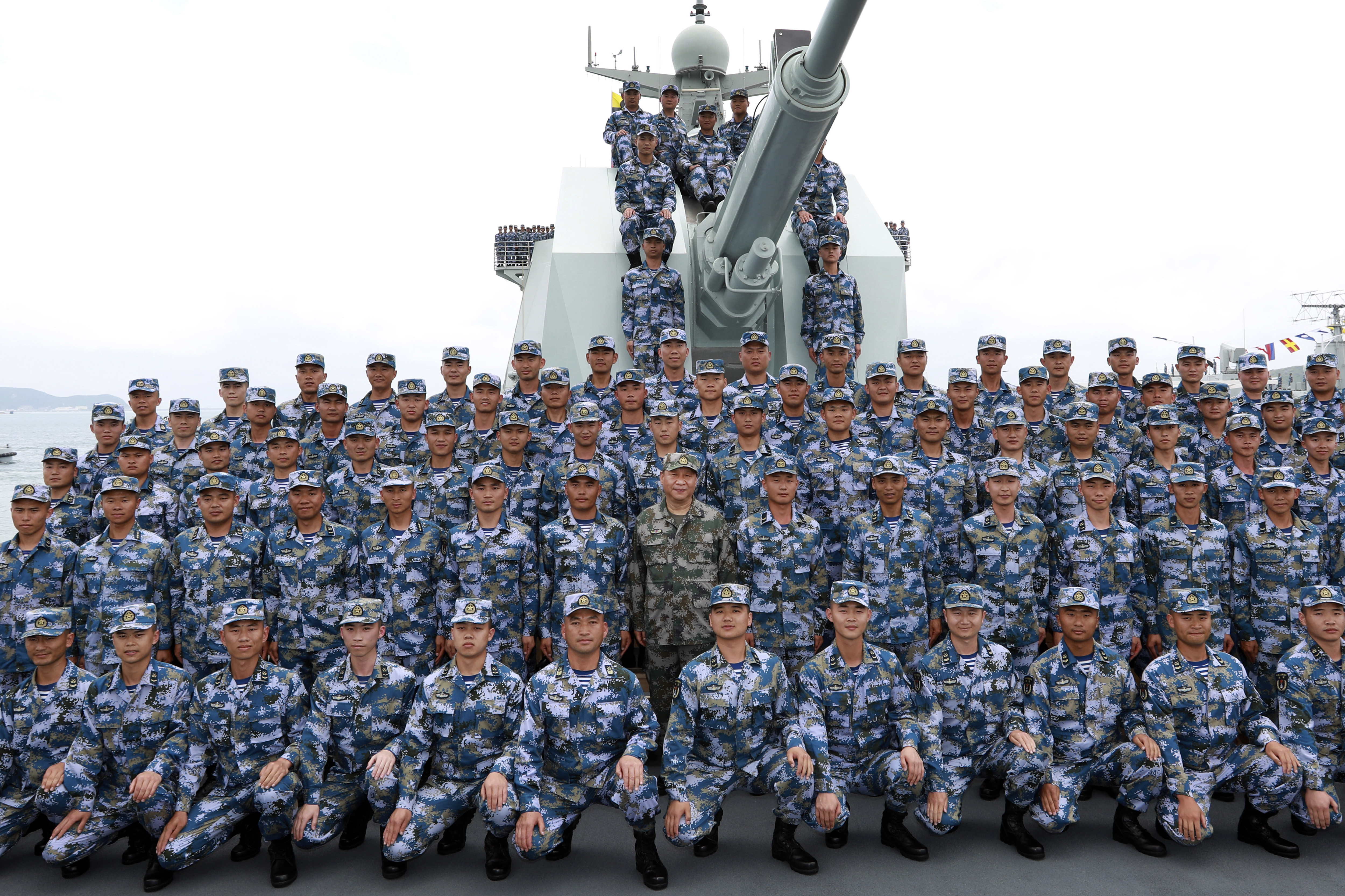 FILE - In this April 12, 2018, file photo released by Xinhua News Agency, Chinese President Xi Jinping, center in green military uniform, poses with soldiers on a navy ship for a photo after he reviewed the Chinese People's Liberation Army (PLA) Navy fleet in the South China Sea. U.S. Defense Secretary Jim Mattis, who has accused China of 