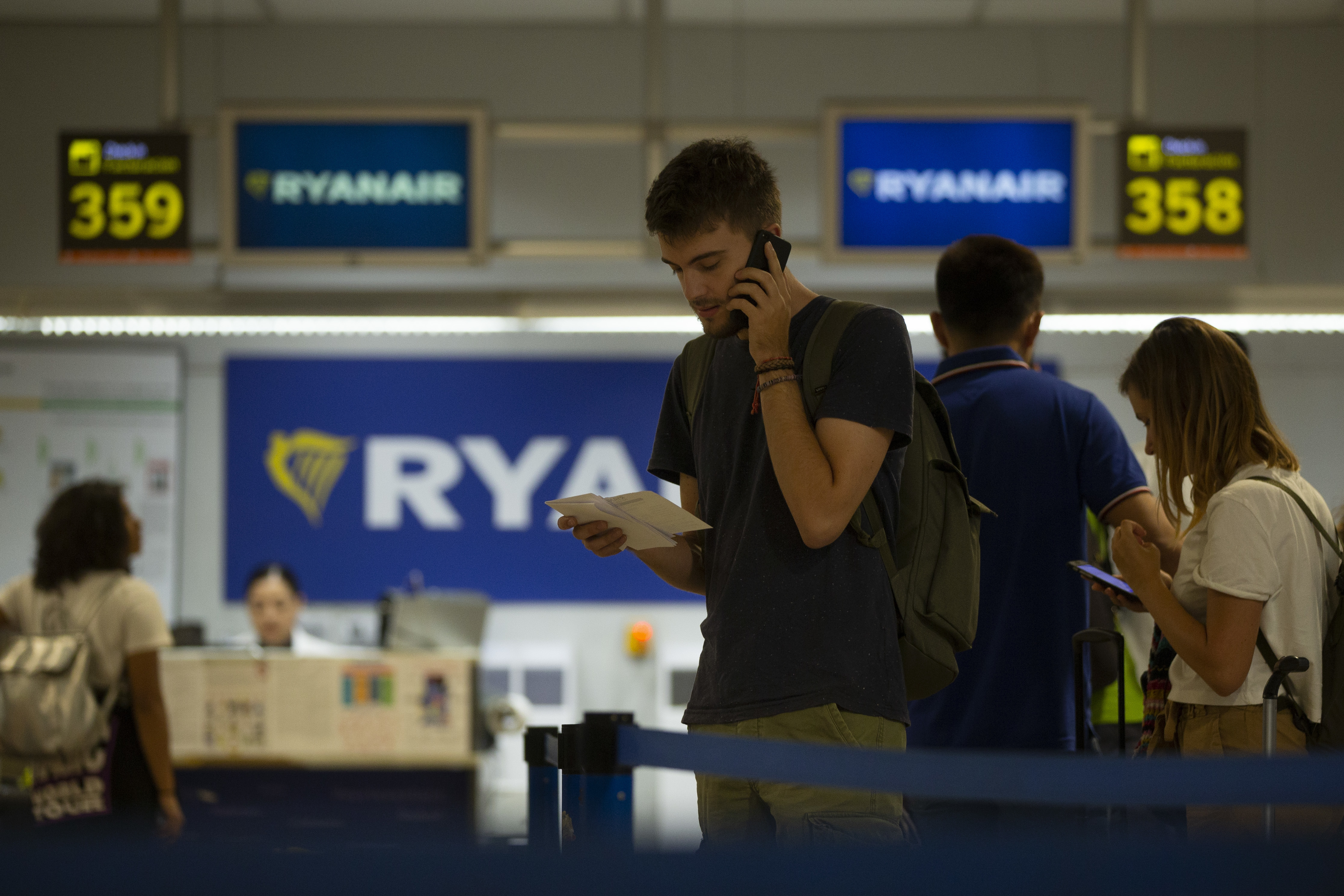 People queue at the Ryanair check-in desk during the first of two days cabin crew strike at Adolfo Suarez-Barajas international airport in Madrid, Wednesday, July 25, 2018. Cabin crew workers for low-cost airline Ryanair went on strike in four European countries over working conditions, forcing thousands of passengers to make last-minute travel adjustments at the peak of the summer holiday season. (AP Photo/Francisco Seco)