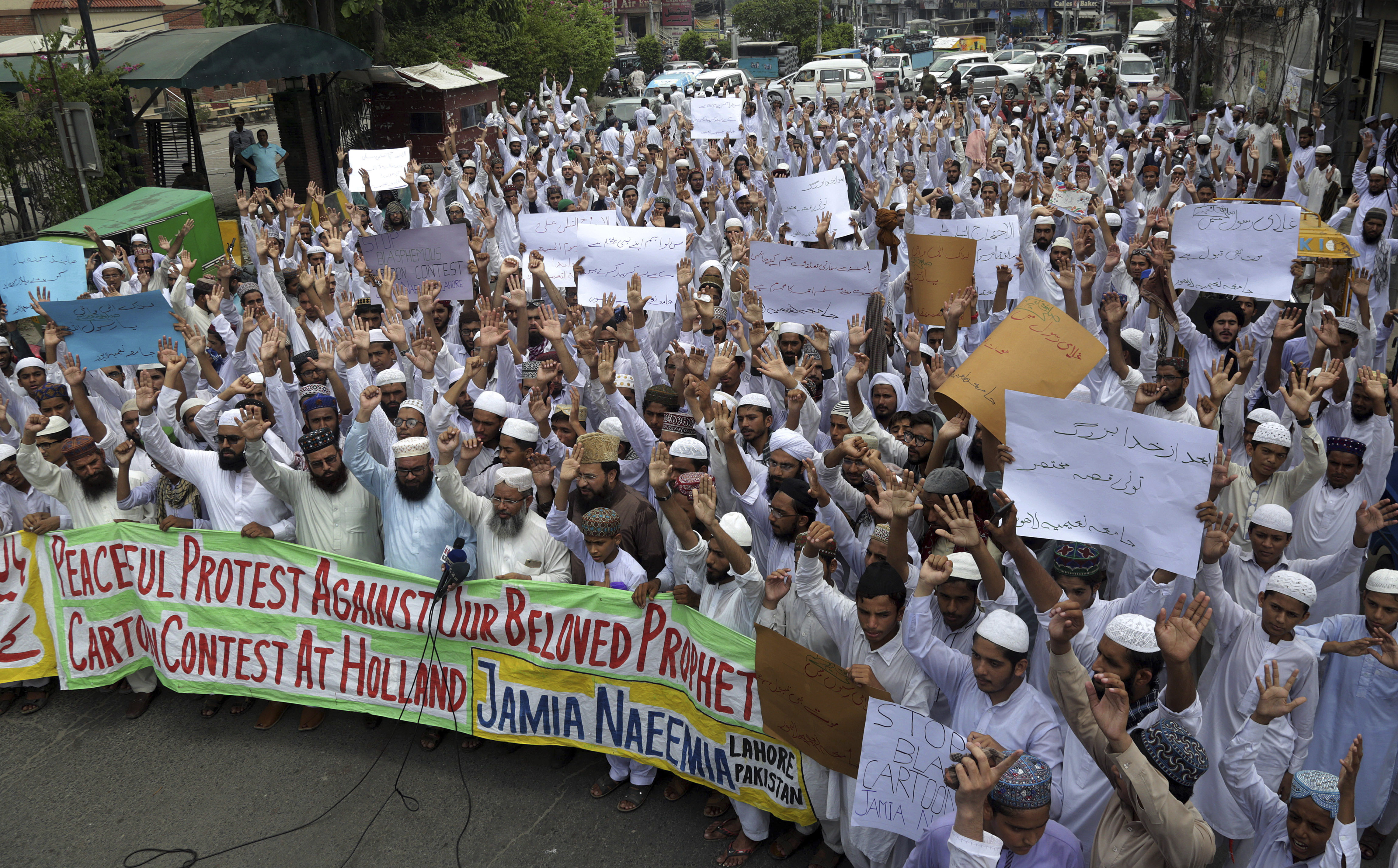 Teacher and students of an Islamic seminary 'Jamia Naeemia' chant slogans during a demonstration in Lahore, Pakistan, Wednesday, Aug. 29, 2018, condemning a cartoon contest planned by Geert Wilders, a Dutch parliamentarian. Members of a Pakistani Islamist group that made surprising gains in last month's national elections rallied against Dutch lawmaker Geert Wilders, who plans to hold a Prophet Muhammad cartoon competition in November. (AP Photo/K.M. Chaudary)