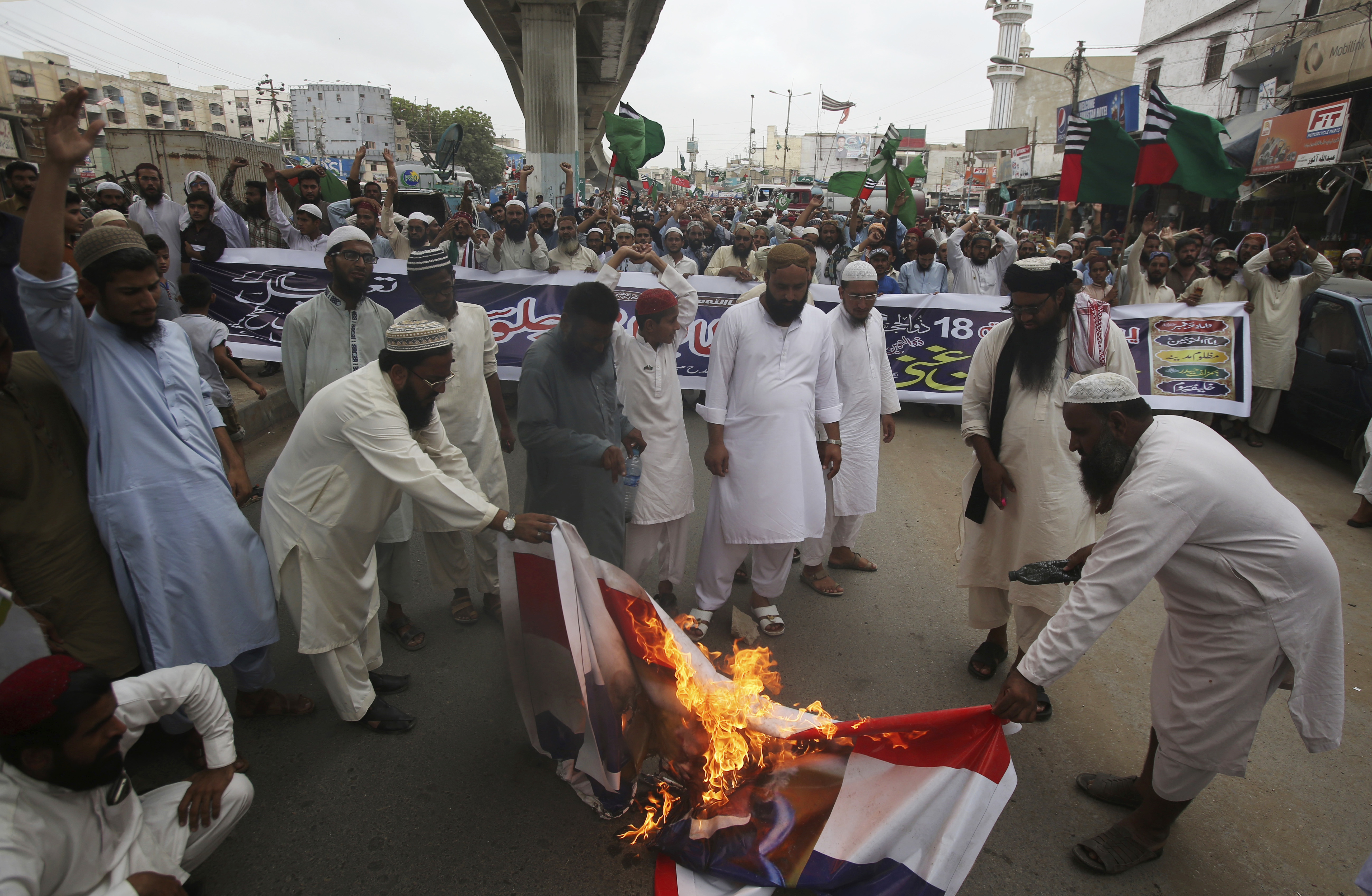Pakistani protesters burn representation of Dutch flags during a protest to condemn the planned anti-Islam cartoon contest, in Karachi, Pakistan, Thursday, Aug. 30, 2018. Thousands of hard-line Islamists angered over a far-right Dutch lawmaker's plans to hold a Prophet Muhammad cartoon contest marched toward Pakistan's capital. (AP Photo/Fareed Khan)