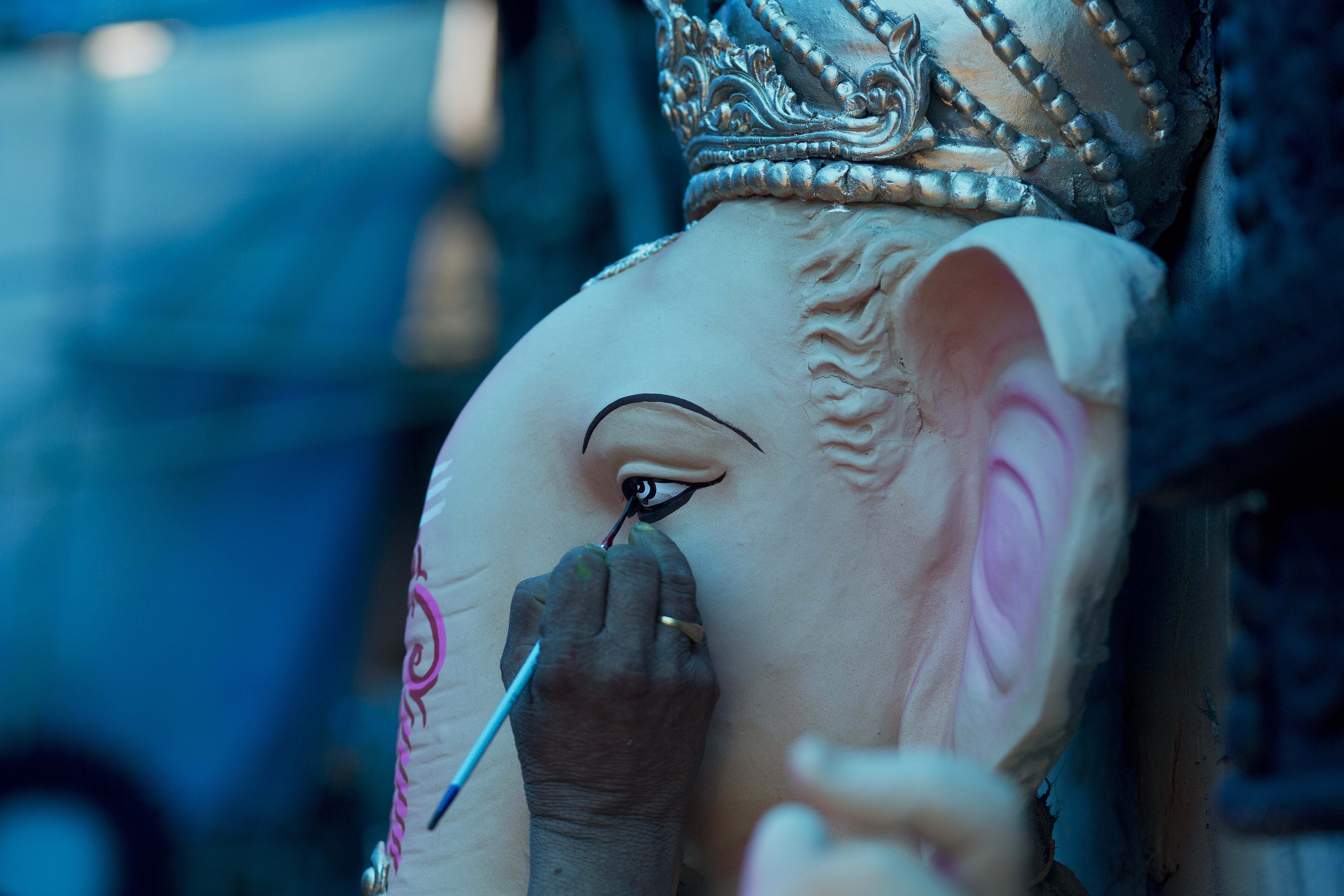 An artisan puts final touches on an idol of Hindu God Ganesha ahead of Ganesha Chaturthi at a workshop in Gauhati, India, Wednesday, Sept. 12, 2018. The ten-day long festival celebrating the birth of Ganesha begins Sept. 13. (AP Photo/Anupam Nath)