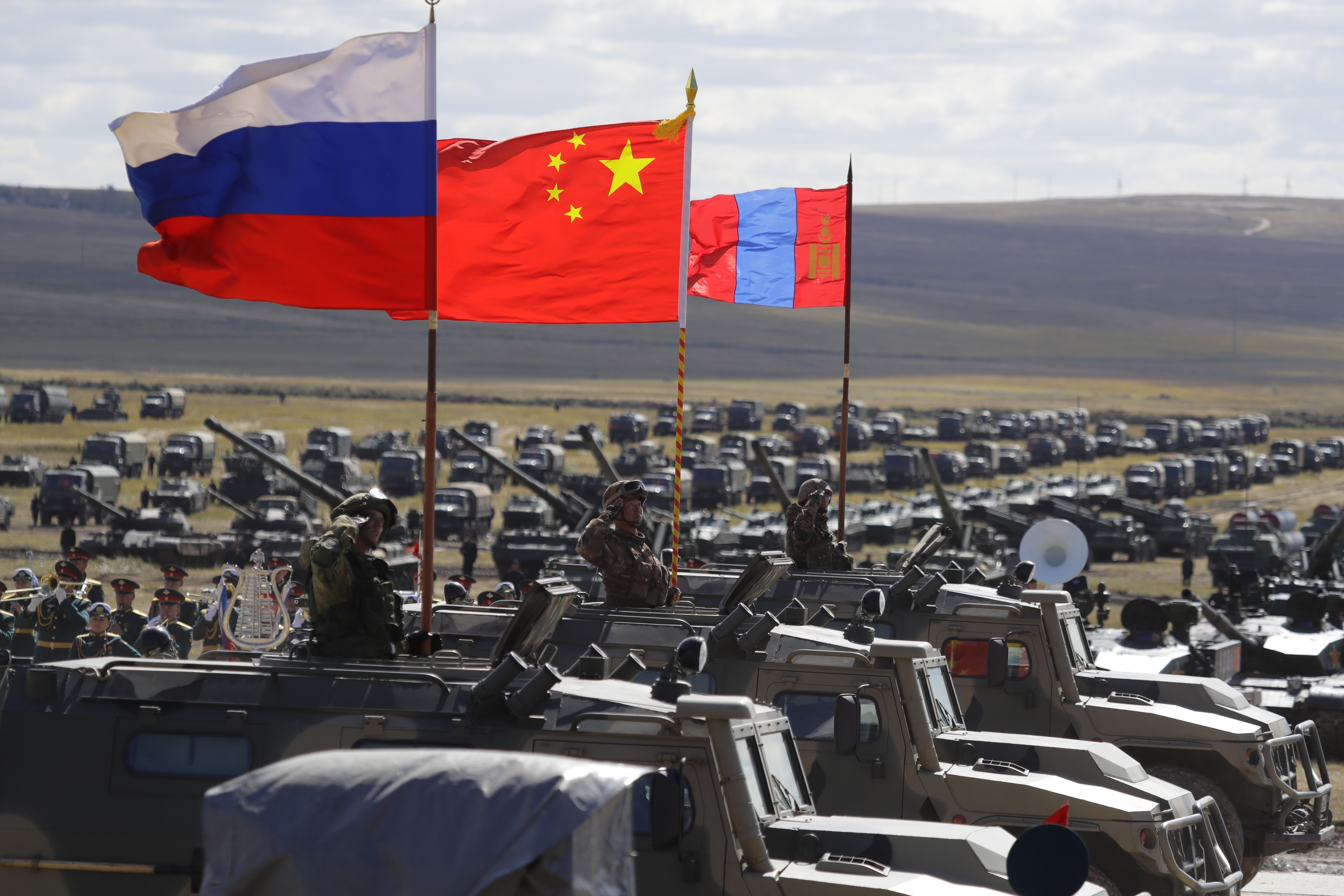 Russian, Chinese and Mongolian national flags set on armored vehicles develop in the wind during a military exercises on training ground 