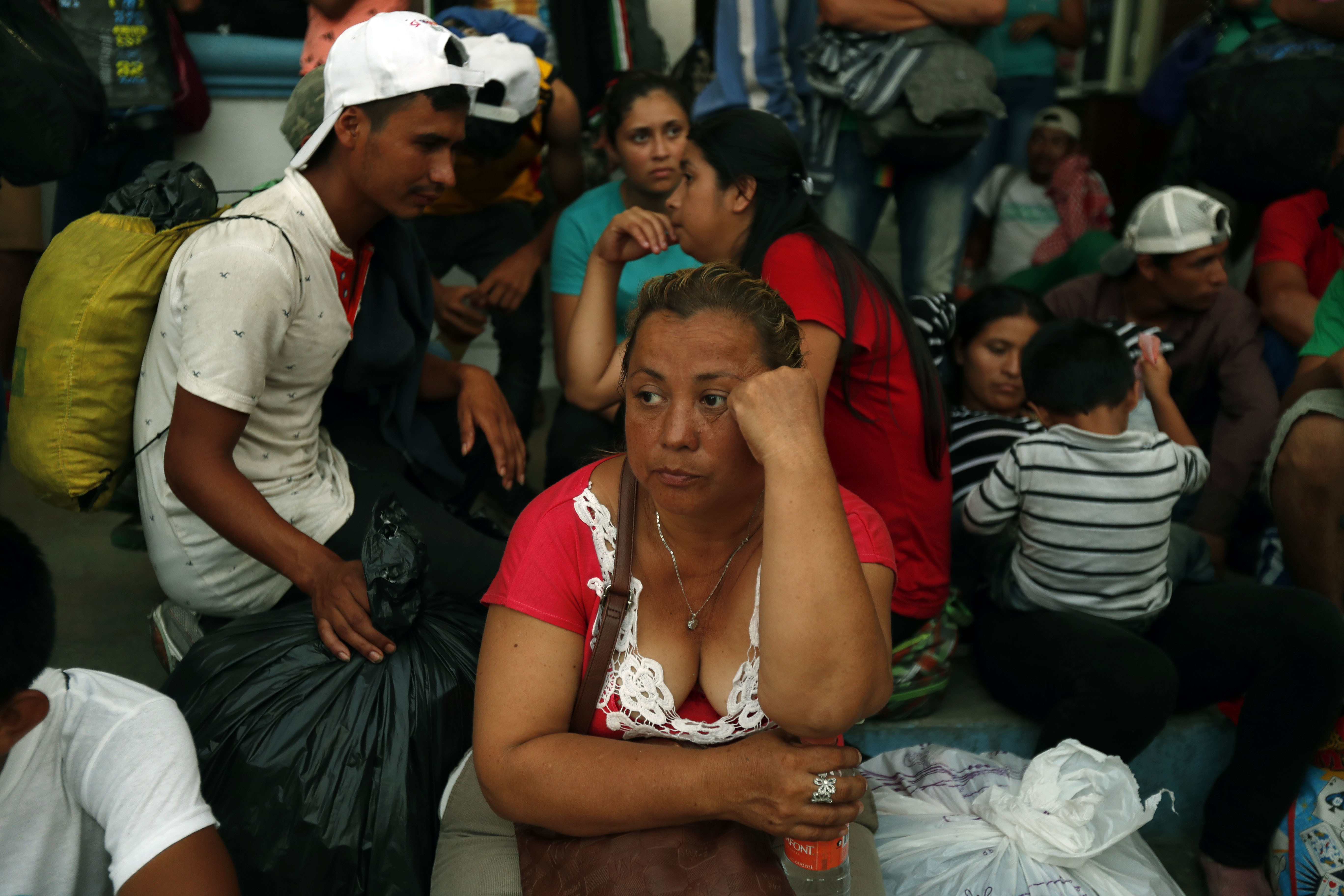 Honduran migrants wait to board a bus at the service of the Mexican National Migration Institute, to voluntarily return to their home country, in Huixtla, Mexico, Wednesday, Oct. 24, 2018. LIttle by little, sickness, fear and police harassment are whittling down the migrant caravan making its way through southern Mexico to the U.S. border. (AP Photo/Moises Castillo)