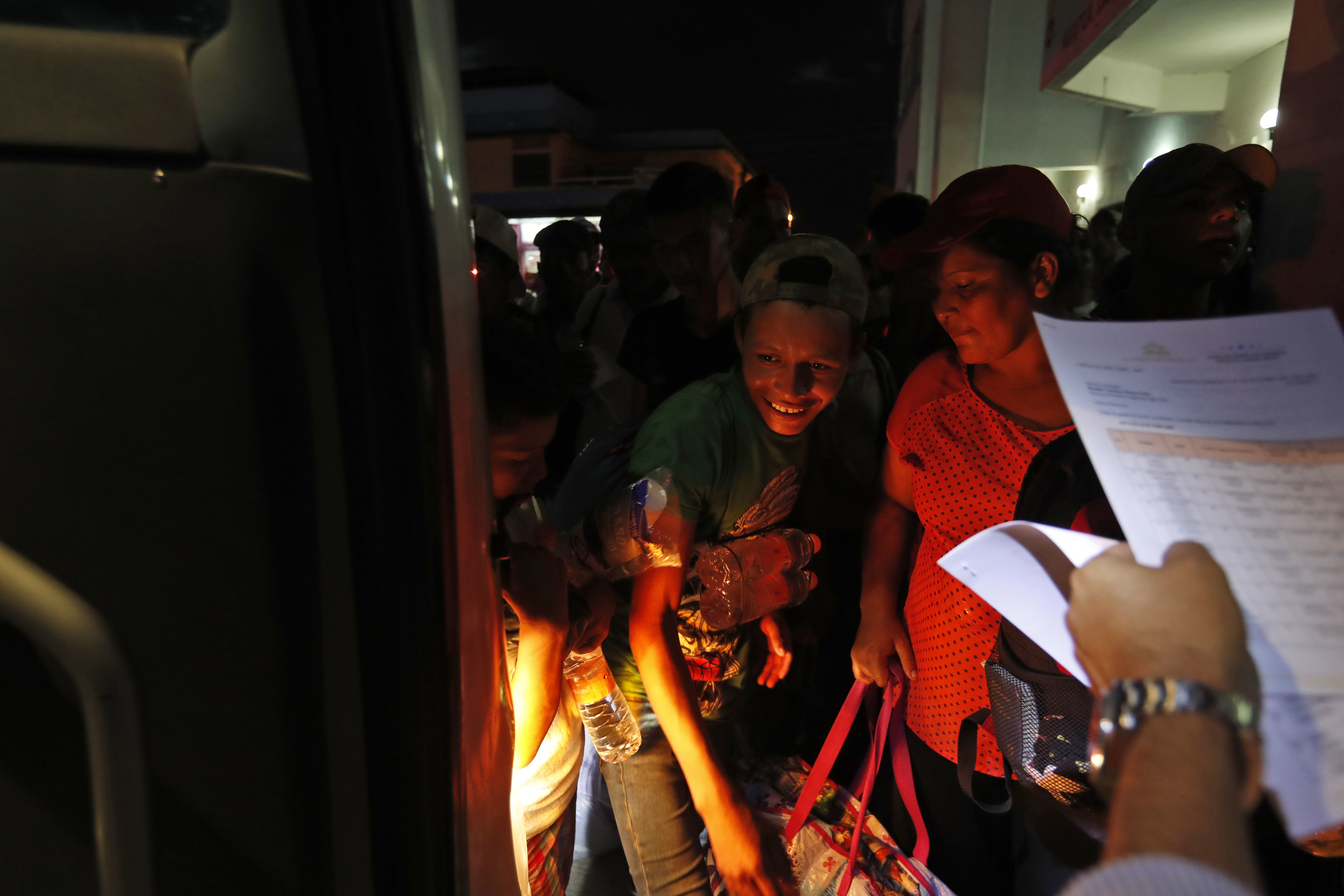 Honduran migrants board a bus at the service of the Mexican National Migration Institute to voluntarily return to their home country, in Huixtla, Mexico, Wednesday, Oct. 24, 2018. LIttle by little, sickness, fear and police harassment are whittling down the migrant caravan making its way through southern Mexico to the U.S. border. (AP Photo/Moises Castillo)