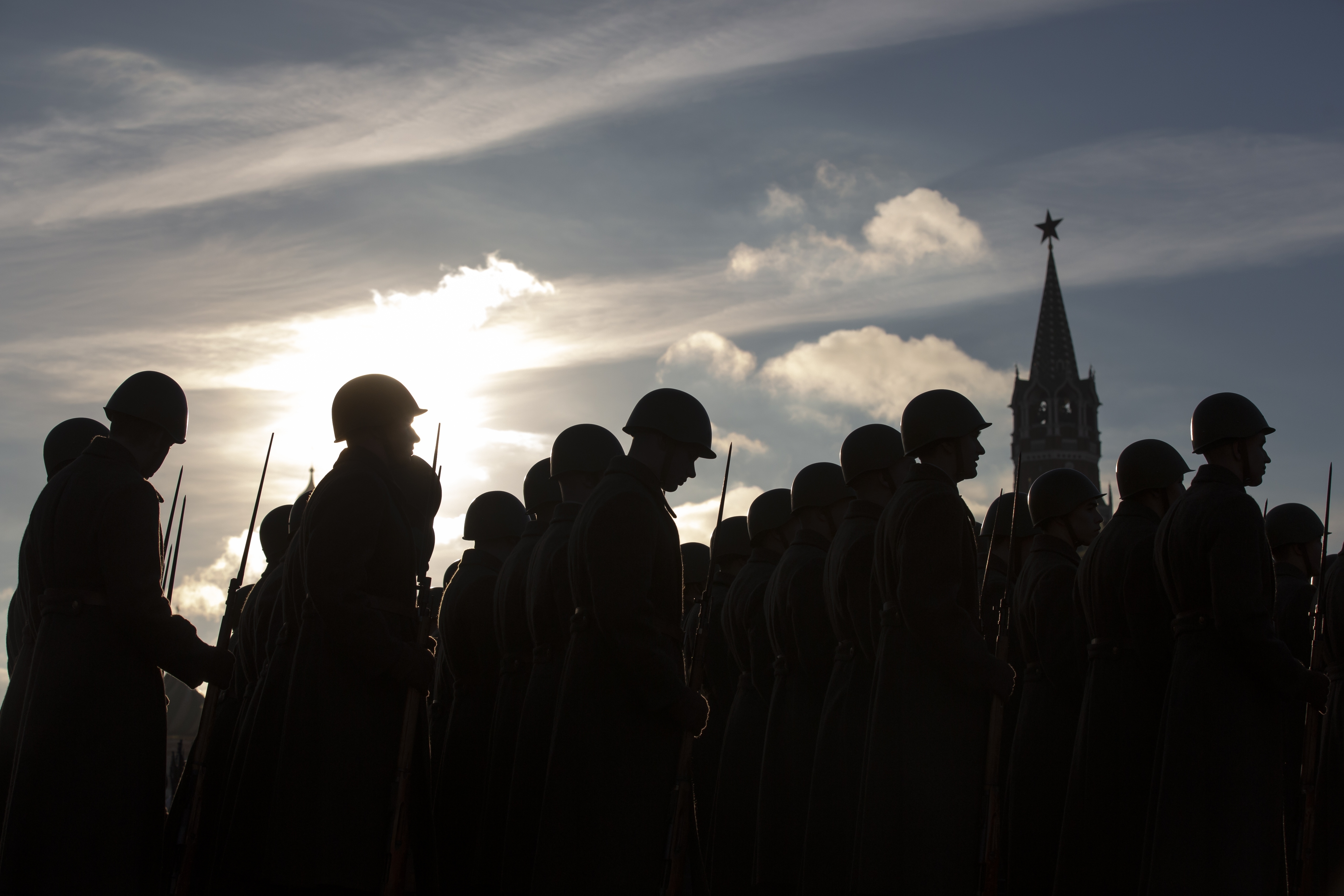 Russian soldiers dressed in Red Army World War II uniforms stand prior to the start of a rehearsal of the Nov. 7 parade in Red Square, with the Spasskaya Tower in the background, in Moscow, Russia, Monday, Nov. 5, 2018. The parade marks the 77th anniversary of a World War II historic parade in Red Square and honored the participants in the Nov. 7, 1941 parade who headed directly to the front lines to defend Moscow from the Nazi forces. (AP Photo/Alexander Zemlianichenko)