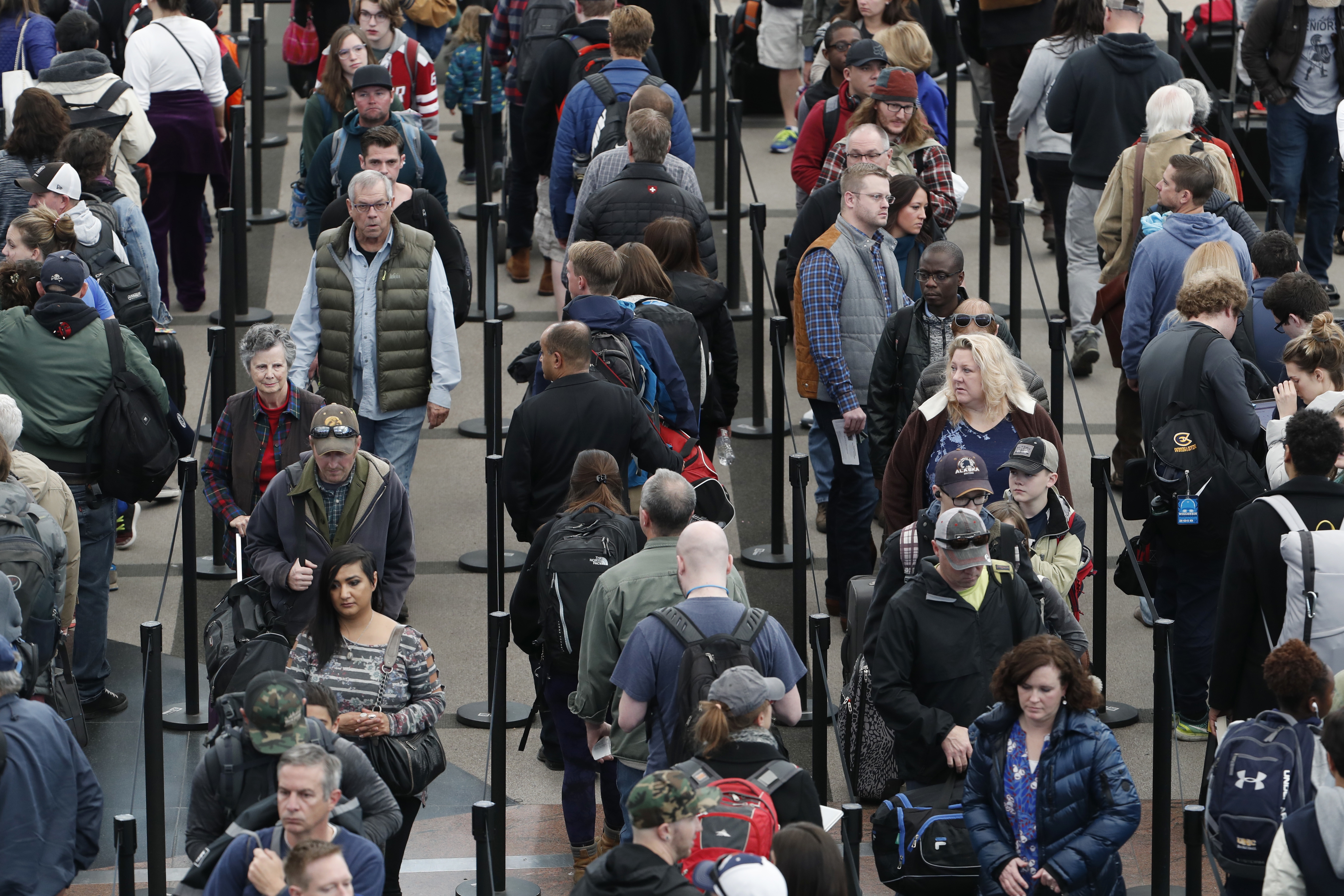Travelers wait in long lines to pass through a security checkpoint in Denver International Airport Wednesday, Nov. 21, 2018, in Denver. Mild weather in parts of the country and lower gasoline prices have potentially created one of the busiest Thanksgiving Day travel periods since 2005, according to AAA. (AP Photo/David Zalubowski)