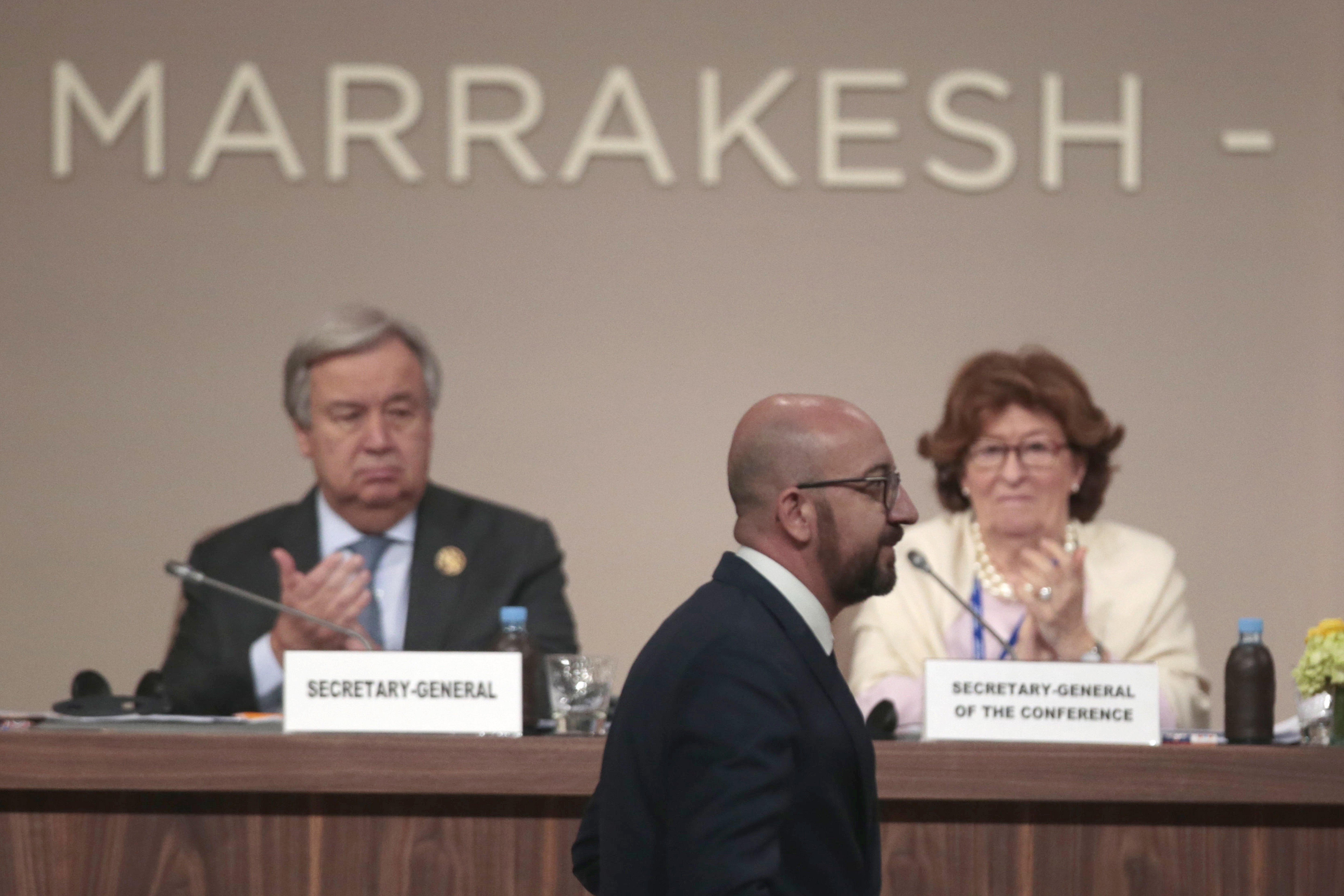 Belgian Prime Minister Charles Michel walks past U.N. Secretary-General Antonio Guterres and Special Representative of the United Nations Secretary-General for International Migration Louise Arbor after addressing delegates during the opening session of a UN Migration Conference in Marrakech, Morocco, Monday, Dec.10, 2018. Top U.N. officials and government leaders from about 150 countries are uniting around an agreement on migration, while finding themselves on the defensive about the non-binding deal amid criticism and a walkout from the United States and some other countries. (AP Photo/Mosa'ab Elshamy)