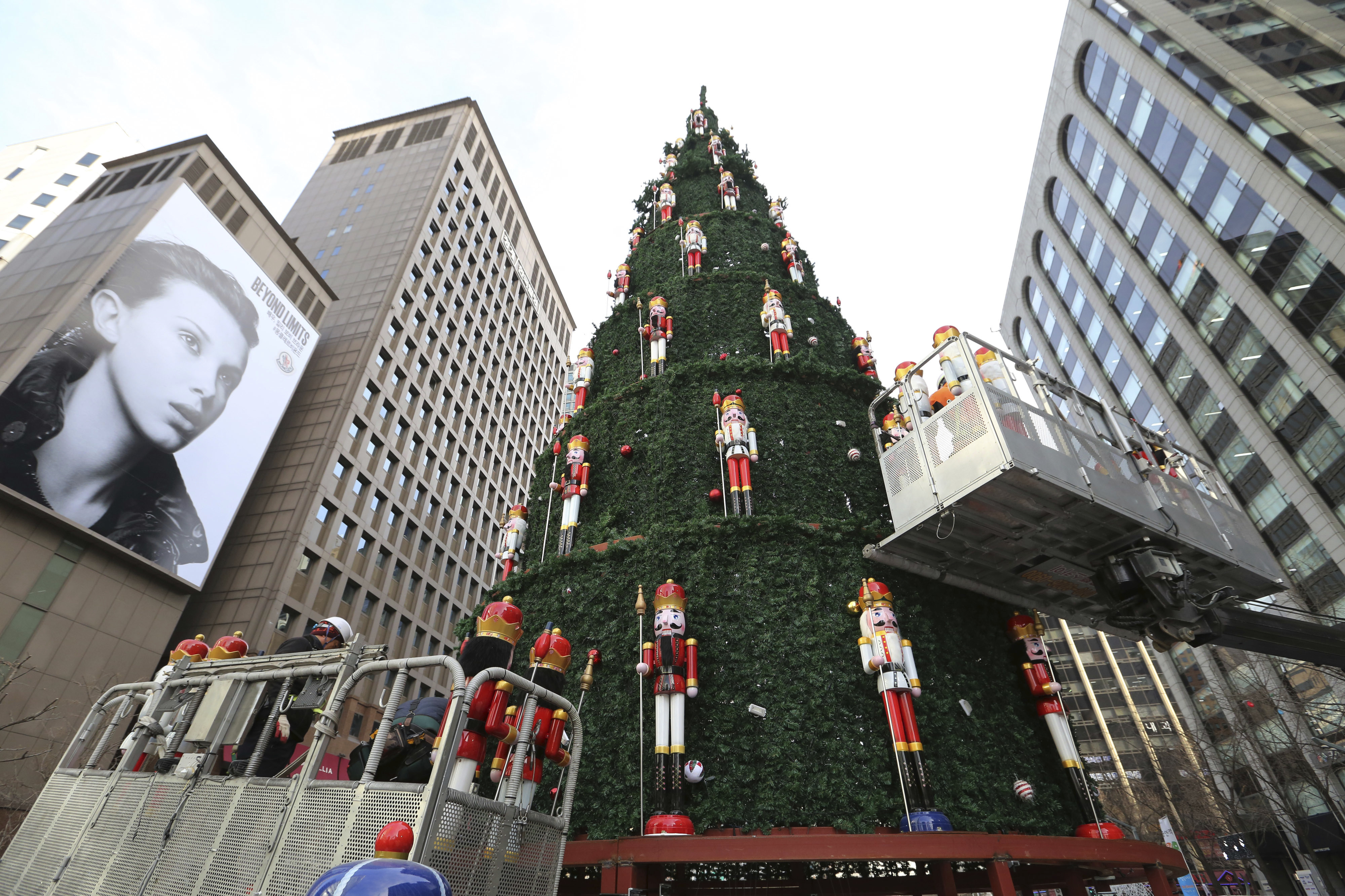 Workers place dolls to decorate a huge Christmas tree in Seoul, South Korea, Thursday, Dec. 6, 2018. Christmas is one of the biggest holidays celebrated in South Korea with some one third of the population being Christians. (AP Photo/Ahn Young-joon)