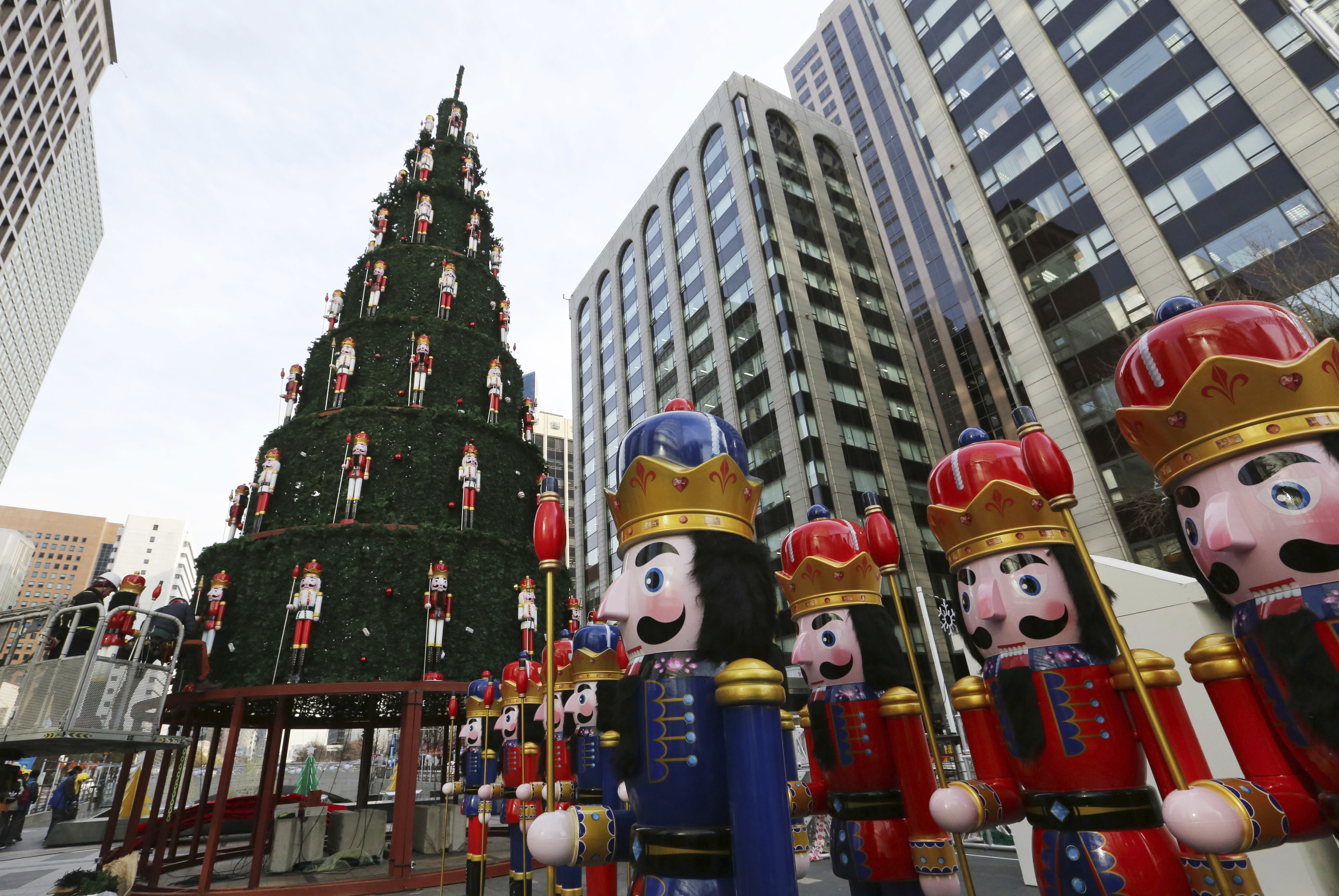 Workers adjust dolls to decorate a huge Christmas tree in Seoul, South Korea, Thursday, Dec. 6, 2018. Christmas is one of the biggest holidays celebrated in South Korea with some one third of the population being Christians.  (AP Photo/Ahn Young-joon)