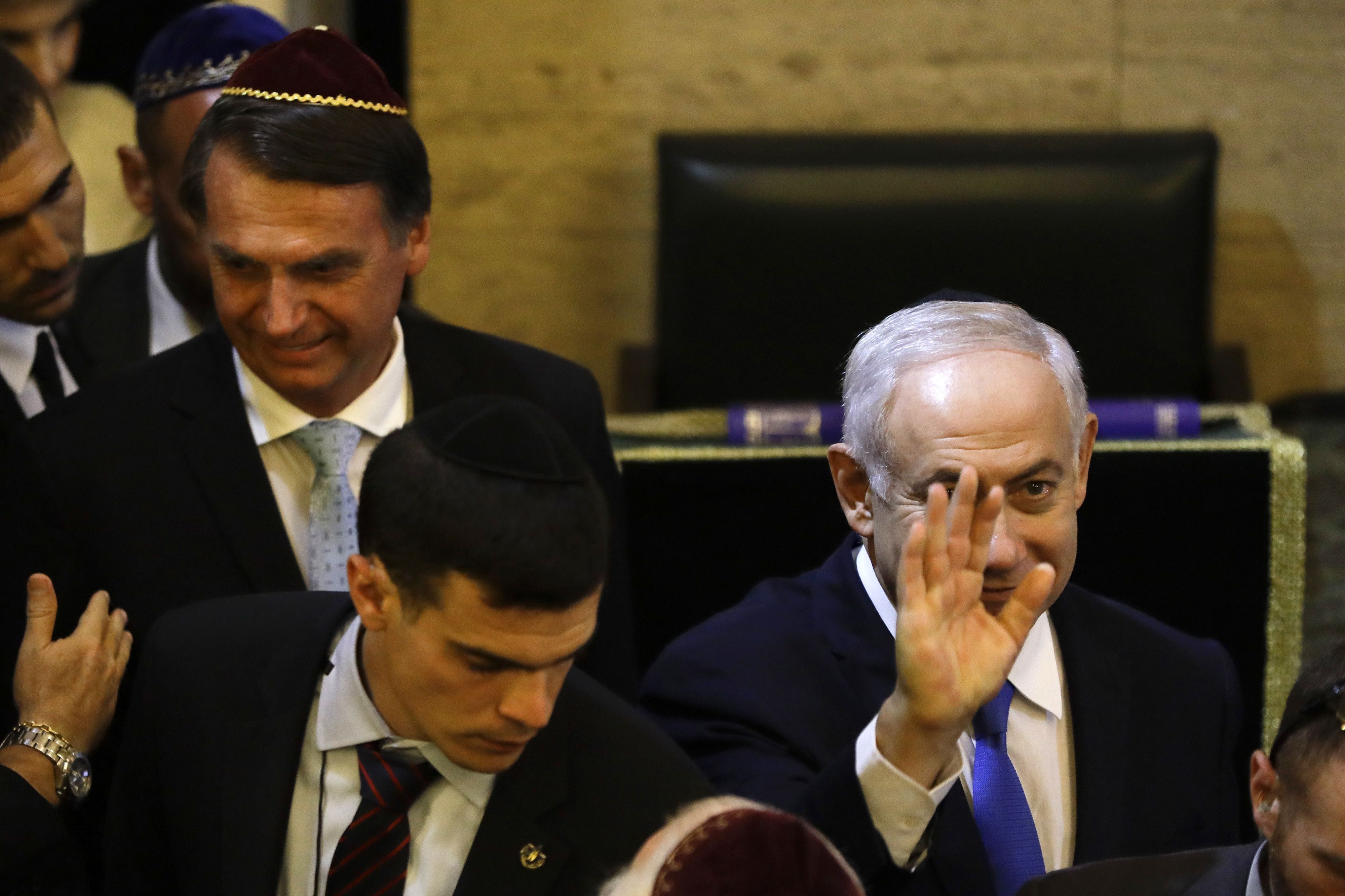 Israel's Prime Minister Benjamin Netanyahu waves as he arrives with Brazil's President-elect Jair Bolsonaro at the Kehilat Yaacov synagogue, in Rio de Janeiro, Brazil, Friday, Dec. 28, 2018. According to the Israeli Embassy, Netanyahu will stay in Rio until Tuesday, when he will travel to Brasilia for the presidential inauguration. (Leo Correa/Pool Photo via AP)