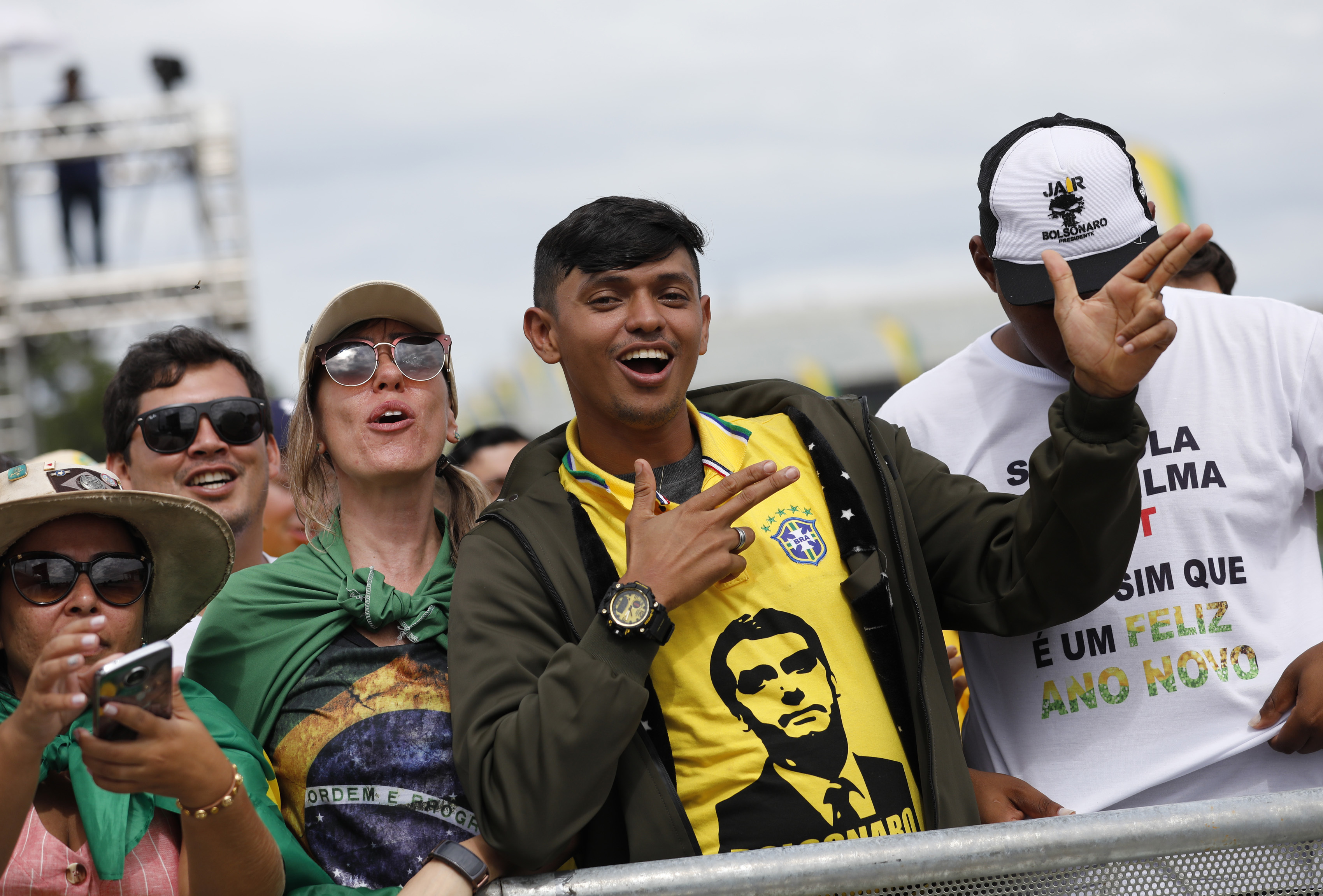 Supporters celebrate before the swearing-in ceremony of Brazil's new President Jair Bolsonaro, in front of the Planalto palace in Brasilia, Brazil, Tuesday Jan. 1, 2019. (AP Photo/Silvia Izquierdo)